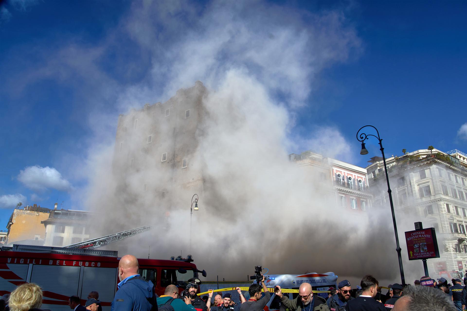 The medieval tower Torre dei Conti in Rome, Italy, is engulfed by a cloud of debris on Monday. (AP Photo/Domenico Stinellis)