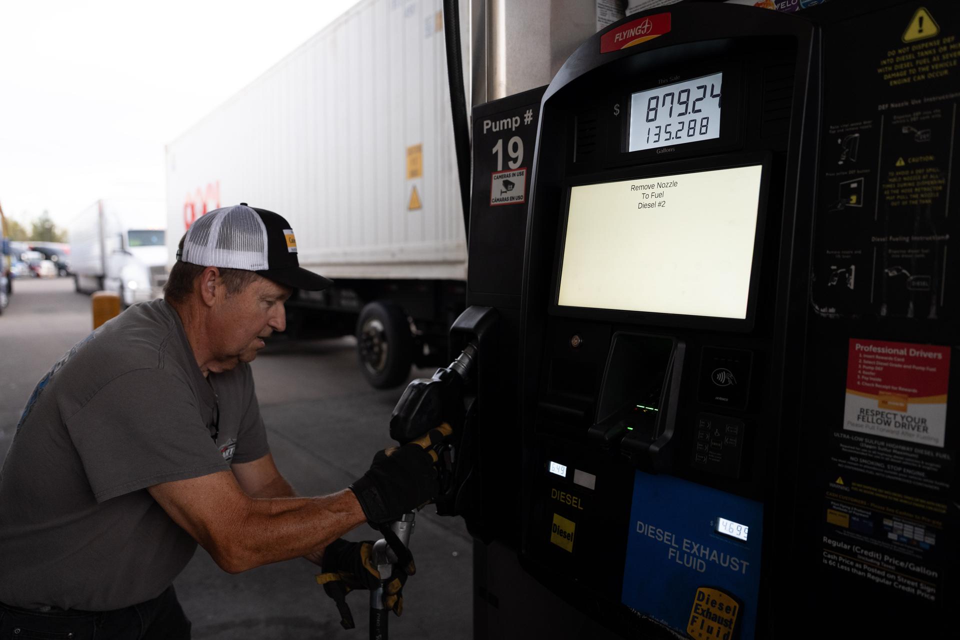Chuck Byrd wraps up after filling two tanks for a truck at a gas station on Tuesday in Aurora, Ore.