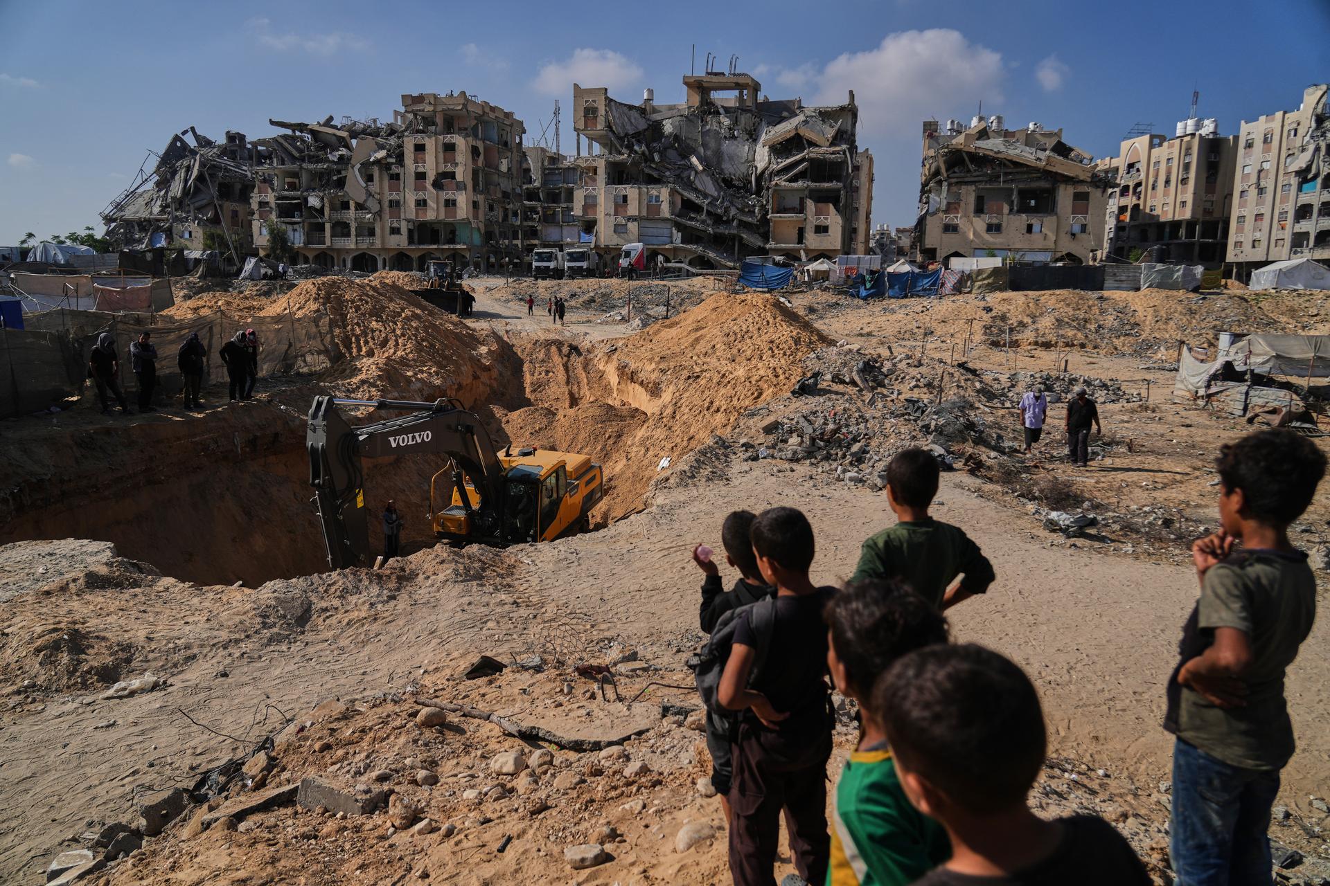 Palestinians watch as Egyptian machinery and workers search for the bodies of hostages in Hamad City, Khan Younis, in the southern Gaza Strip on Tuesday. (AP Photo/Abdel Kareem Hana).