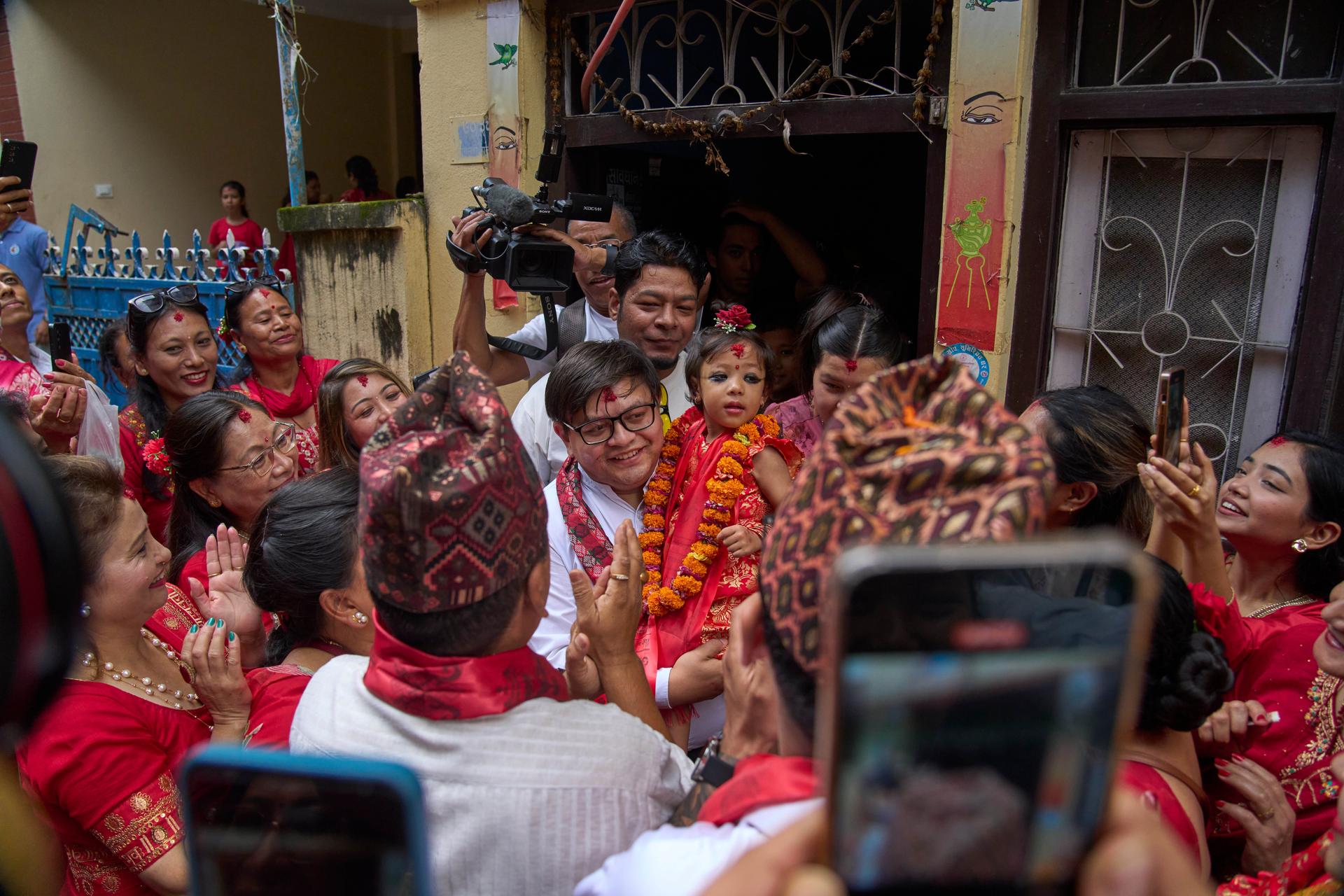 Nepal's newly appointed living goddess, Kumari Aryatara Shakya, is carried by a family member on Tuesday. (AP Photo/Niranjan Shrestha)