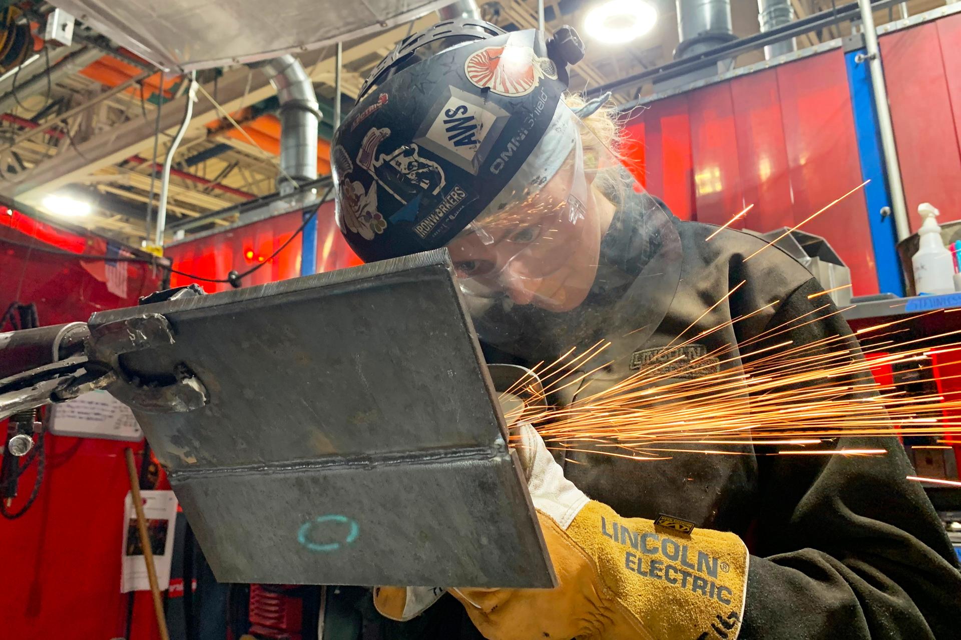 Student Mikala Sposito welds at Washtenaw Community College on May 1, in Ann Arbor., Mich.