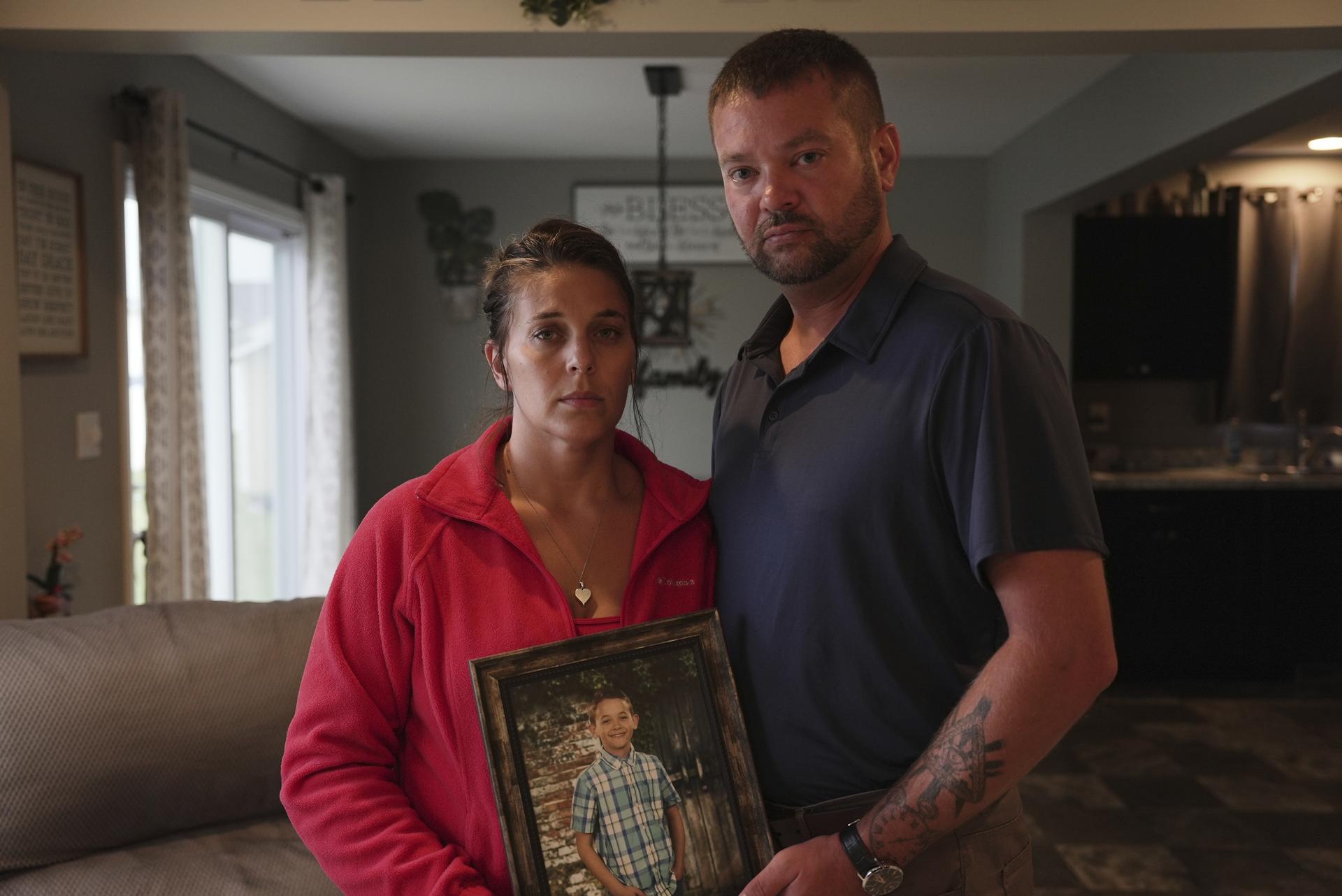 Ashlee and Erik Dahlberg hold a photo of their late son, Liam, in their home in Lowell, Ind., on Aug. 12. (AP Photo/Laura Bargfeld)