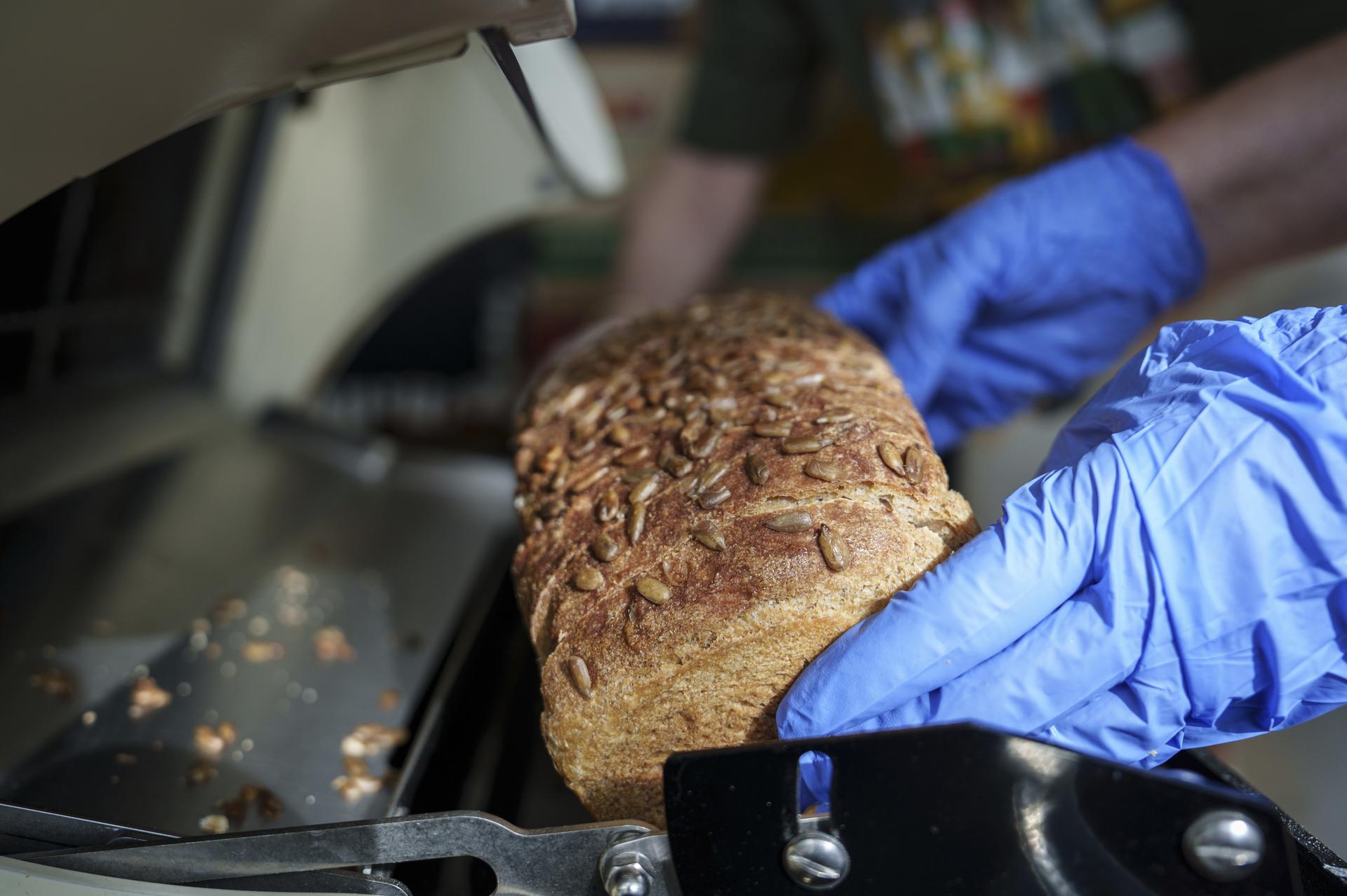Volunteers slice bread from Community Loaves at the Edmonds Food Bank in Edmonds, Wash., on Sept. 8. (AP Photo/Annika Hammerschlag)