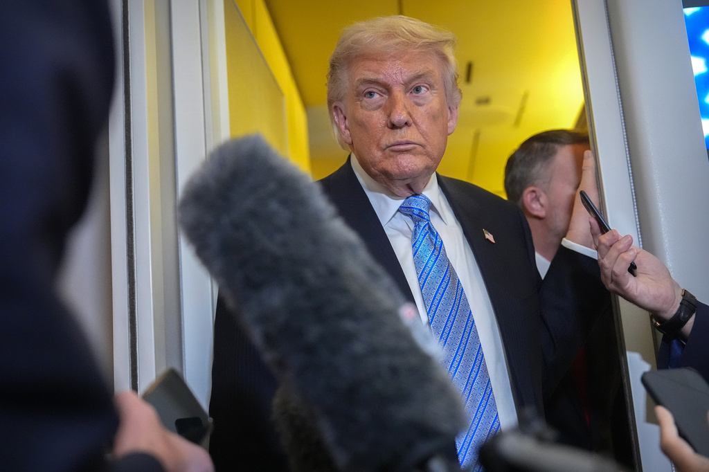 President Donald Trump speaks to reporters aboard Air Force One on Friday. (AP Photo/Mark Schiefelbein)