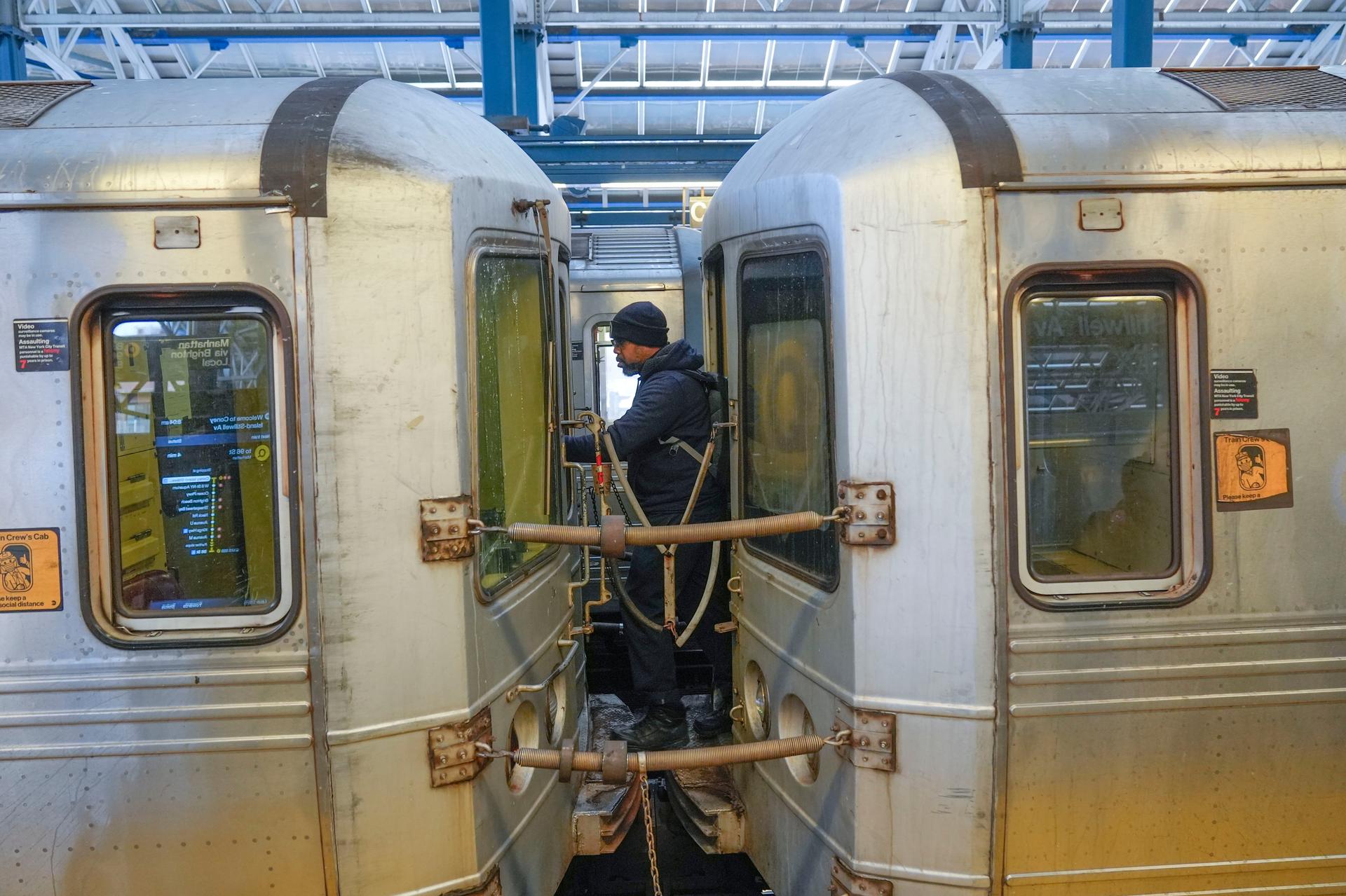 A train conductor walks between subway cars in New York in January. (AP Photo/Seth Wenig)