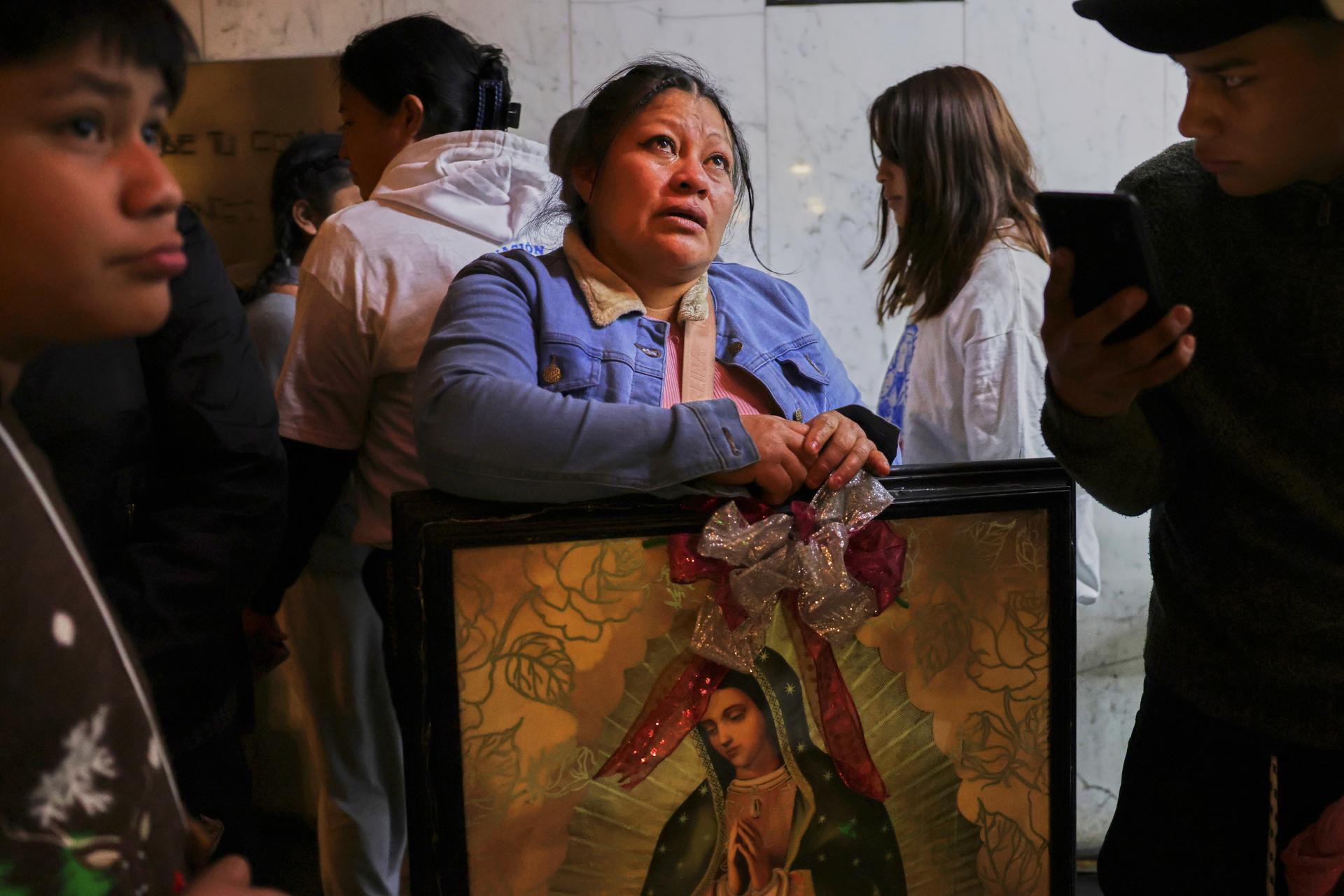 A woman cries as she looks up at the Virgin of Guadalupe image hanging on the wall at the Basilica of Our Lady of Guadalupe in Mexico City, on her feast day on Friday. (AP Photo/Claudia Rosel).