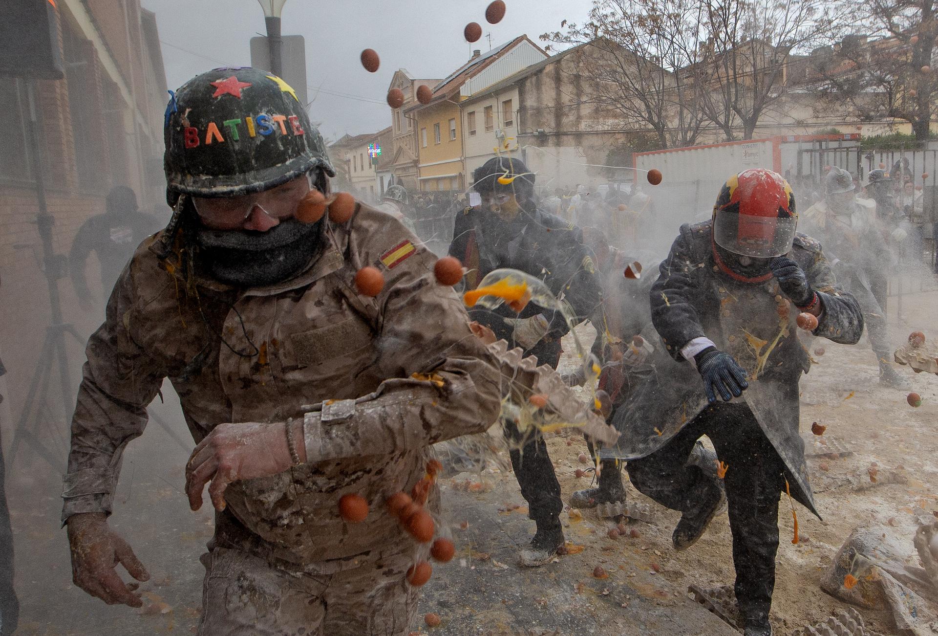 Revellers take part in the Els Enfarinats festival, a battle using flour, eggs and firecrackers, in the town of Ibi near Alicante, Spain, Sunday.