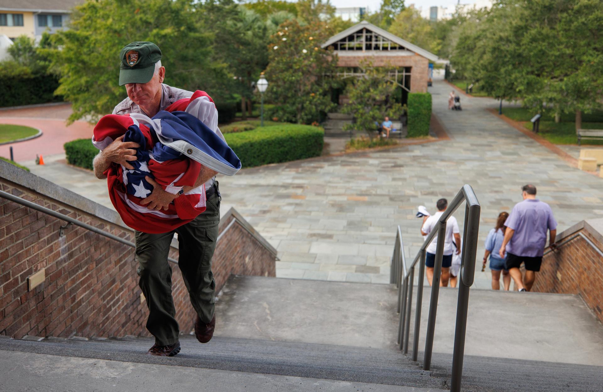 Park rangers spend the first morning of the government shutdown closing down the Fort Sumter National Monument center including taking down the American flag Wednesday, in Charleston, S.C.