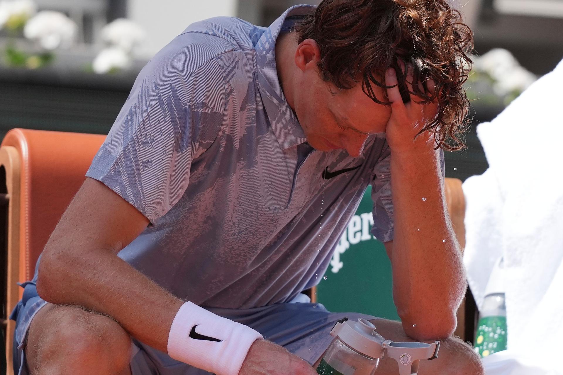 Jannik Sinner of Italy reacts as he cools himself with the water during a break at the second round men's singles tennis match at the French Open tennis tournament in Paris on Thursday. (AP Photo/Thibault Camus)