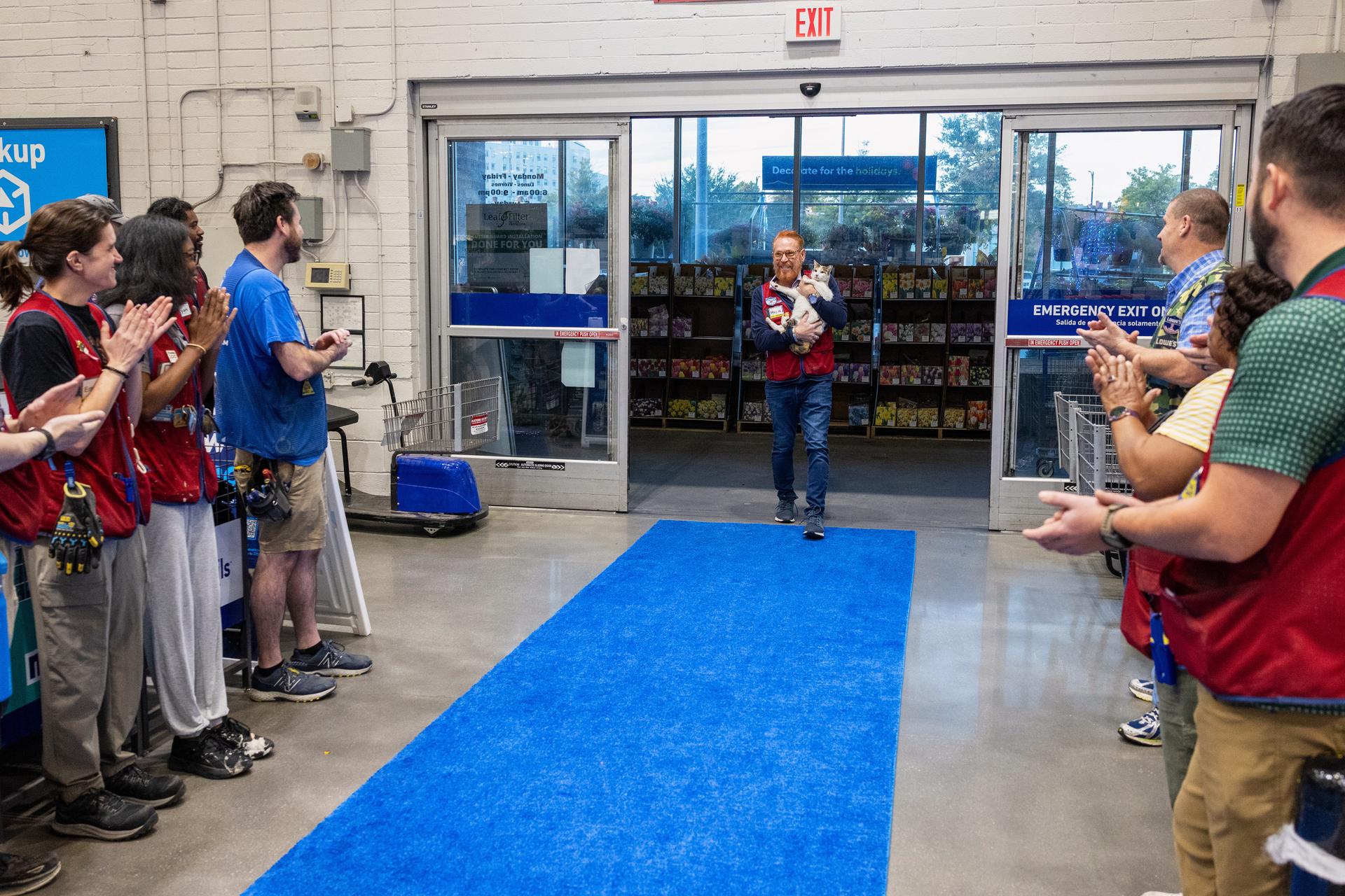 Employees welcome back Francine, the store cat, at the Richmond, Va., Lowe's, on Tuesday.