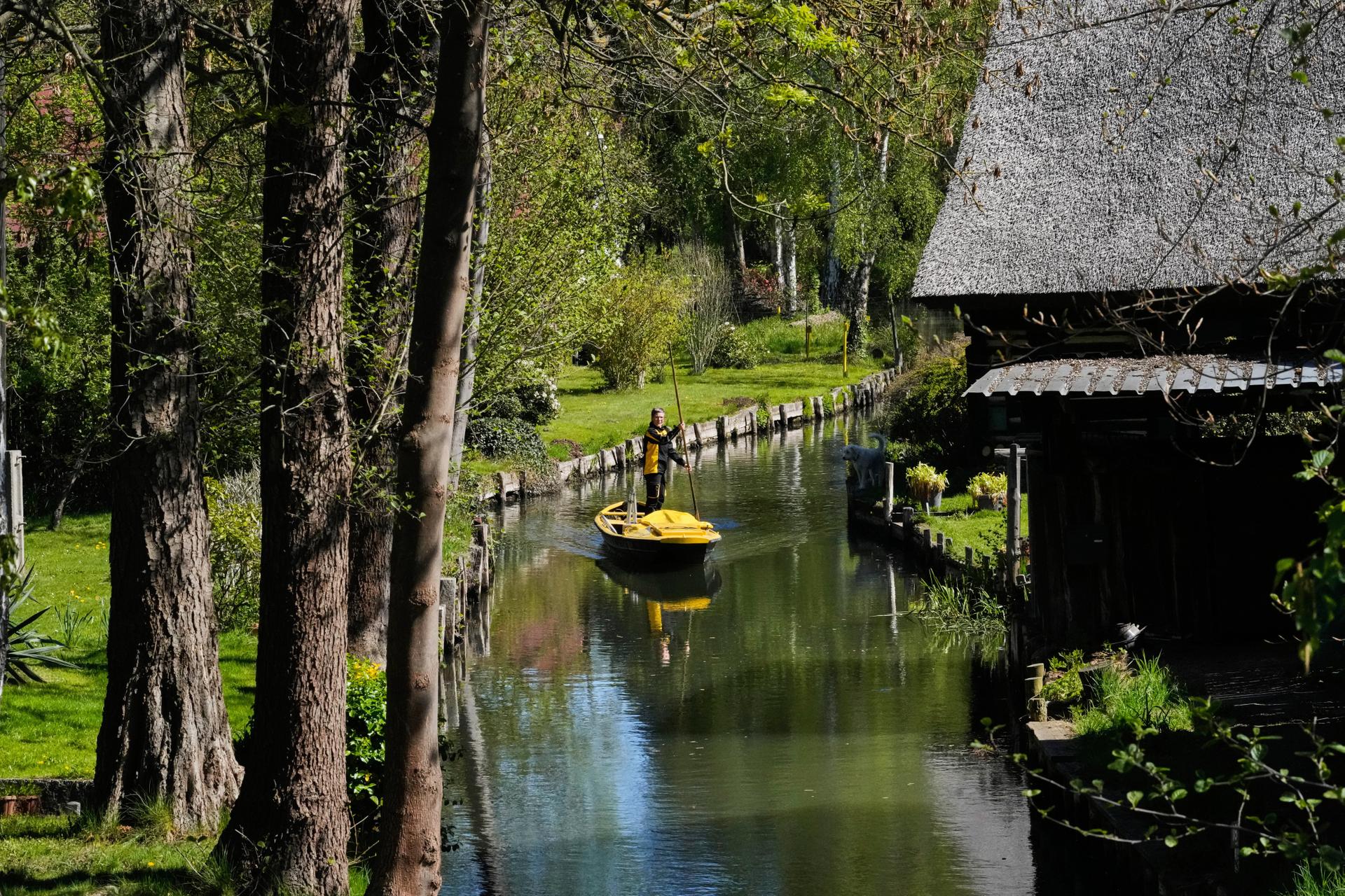 Postal worker Andrea Bunar stands on a boat on Wednesday during the first tour of the summer when mail is delivered on the waterways in the village Lehde in Luebbenau, Germany. (AP Photo/Markus Schreiber)