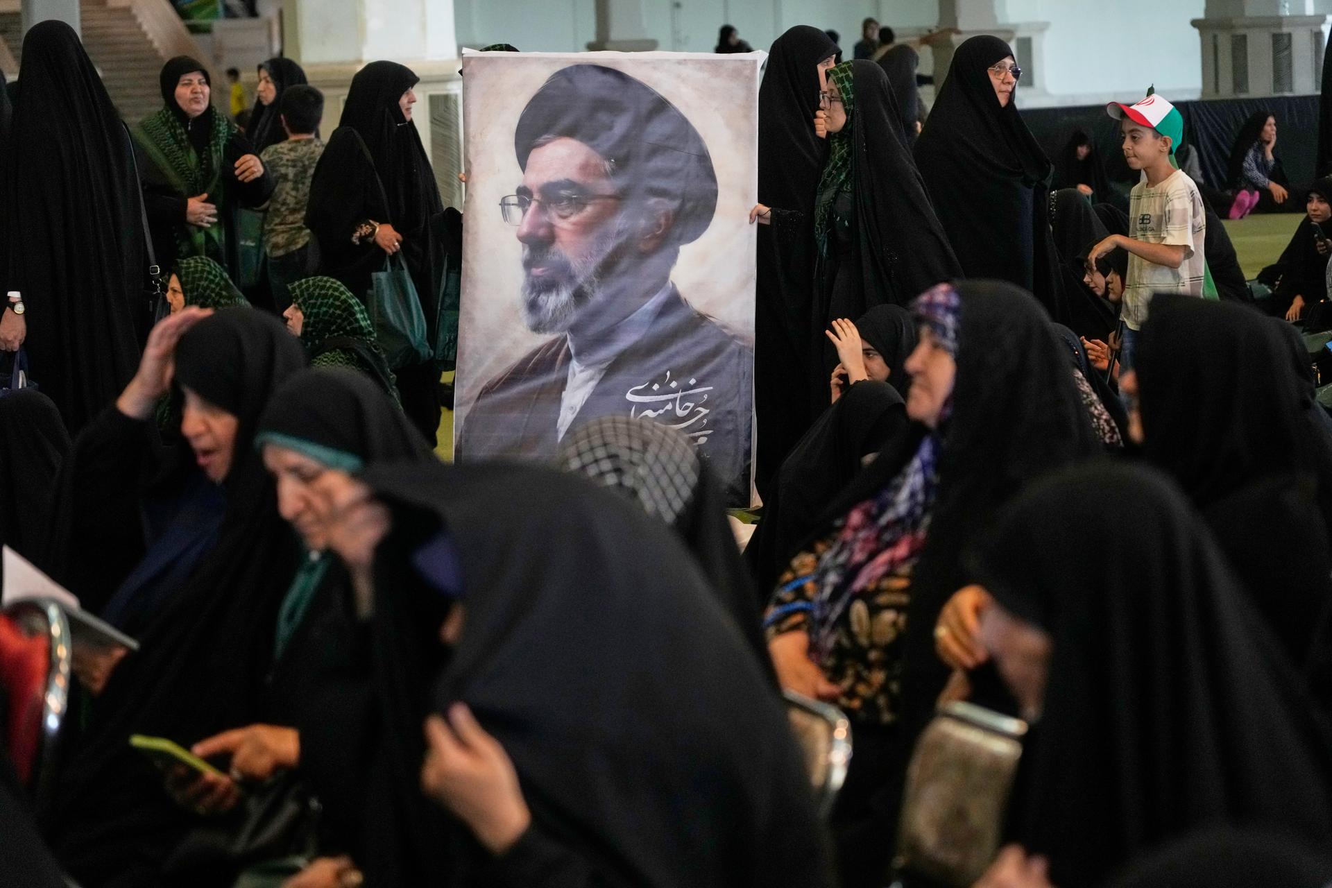 Women gather around a portrait of Iran's Supreme Leader, Ayatollah Mojtaba Khamenei, during a ceremony honoring the armed forces and those killed in the war with Israel and the U.S. in Tehran, Iran, on Sunday. (AP Photo/Vahid Salemi)