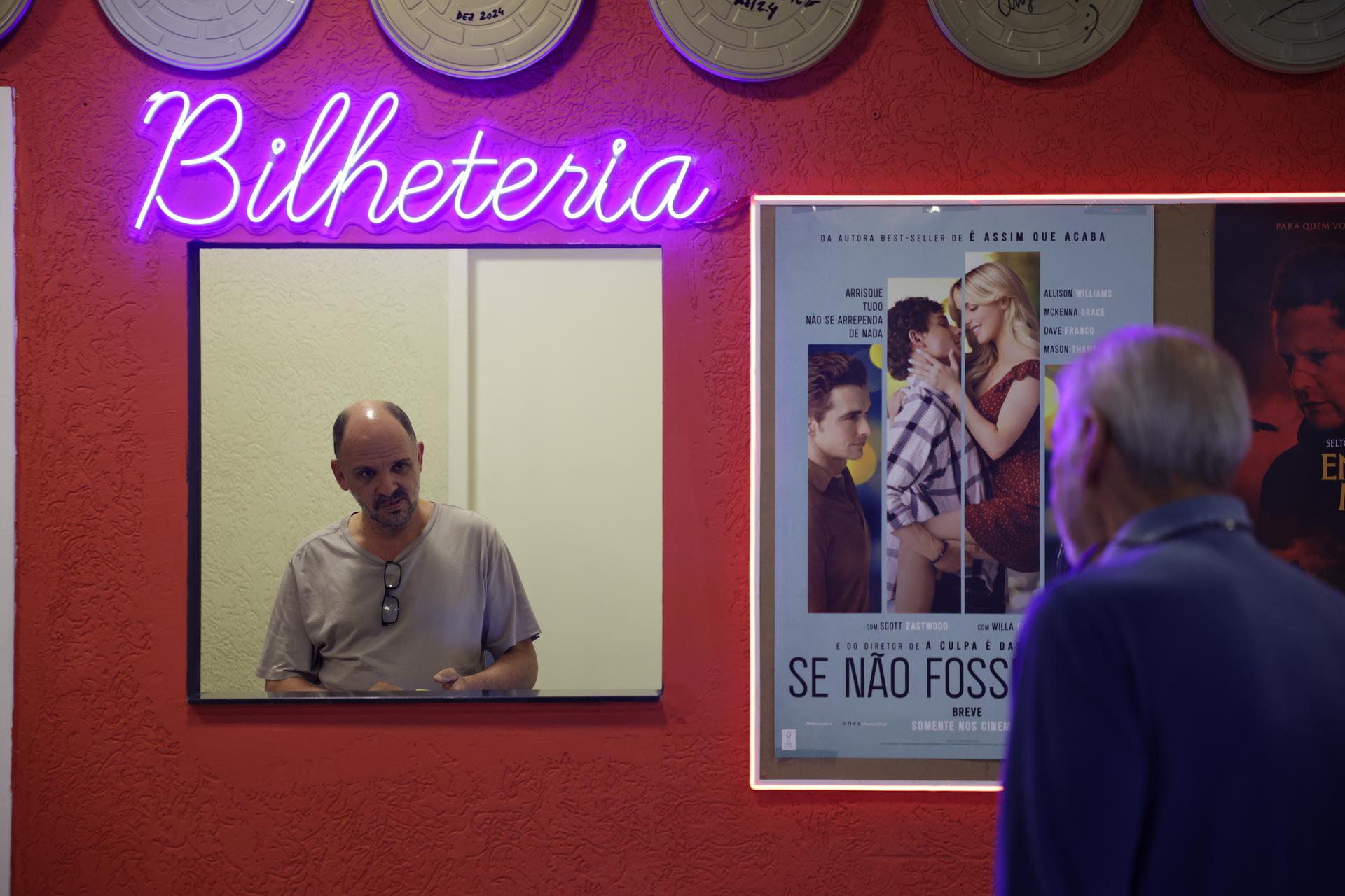 Carlos Costa sells movie tickets at his Cine LT3 in an old parking garage in Sao Paulo on Thursday. (AP Photo/Ettore Chiereguini)