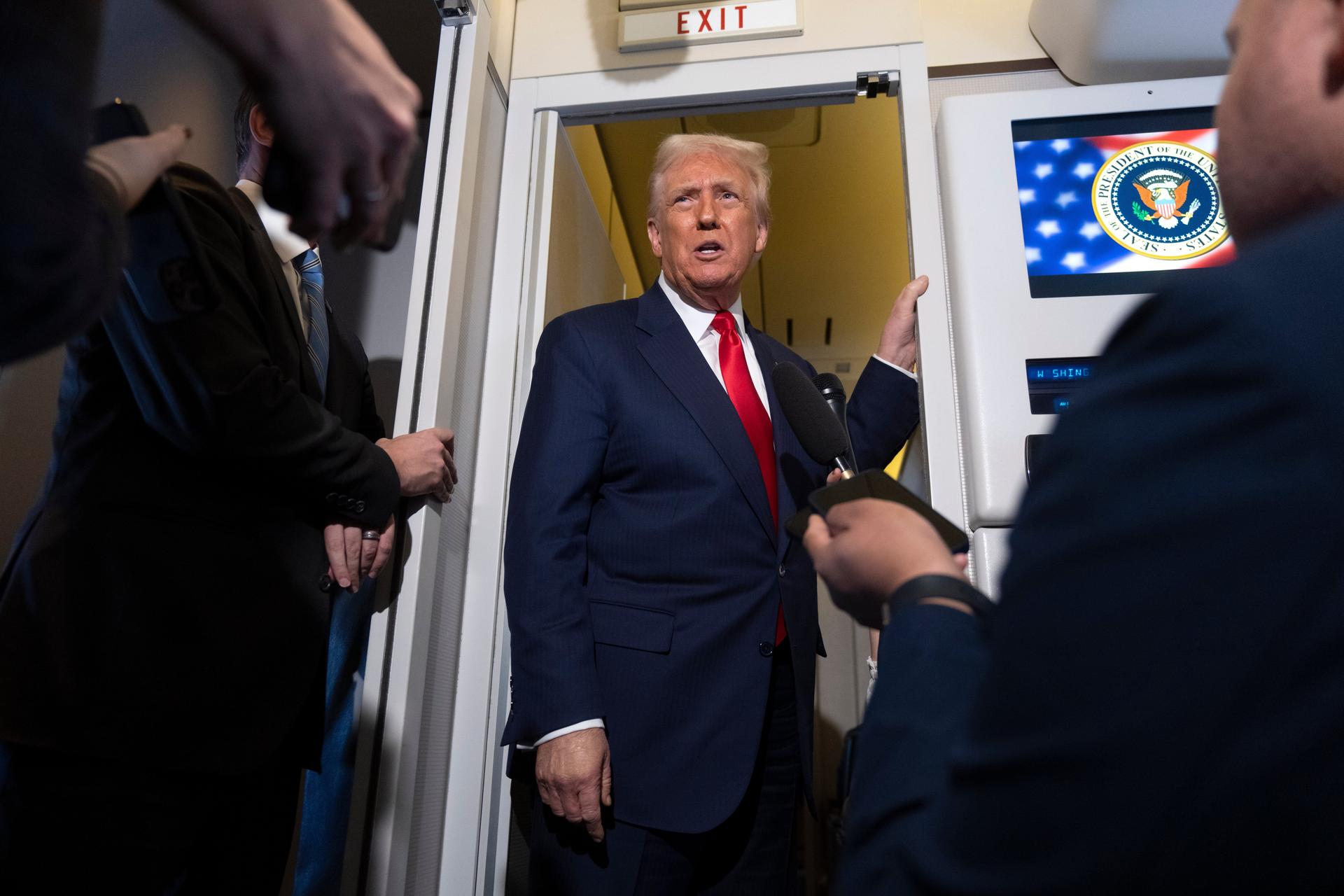 President Donald Trump speaks with reporters aboard Air Force One shortly after taking off from Busan, South Korea.