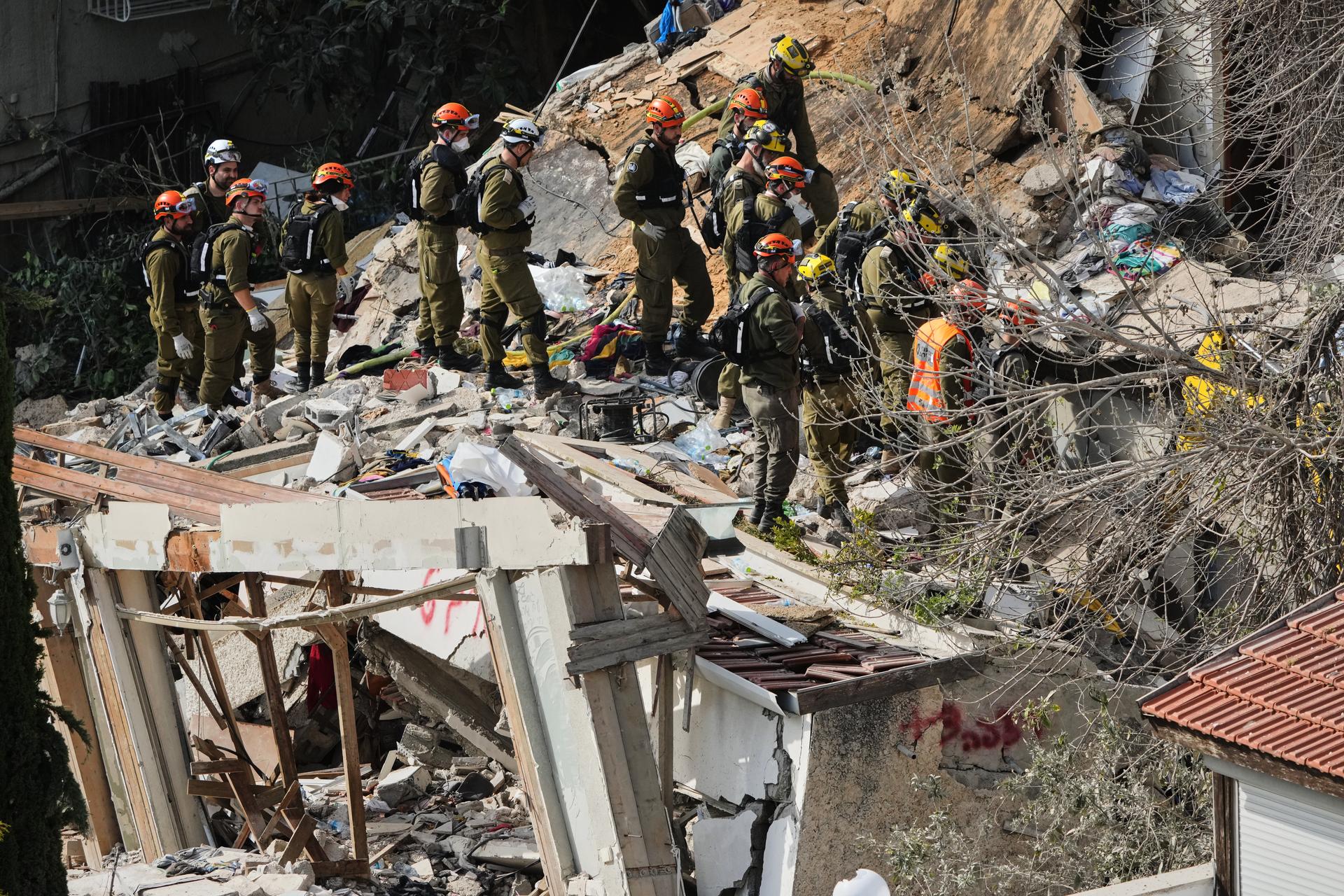 Israeli rescue teams search for missing people amid the rubble of a residential building a day after it was struck by an Iranian missile in Haifa, Israel, Monday.