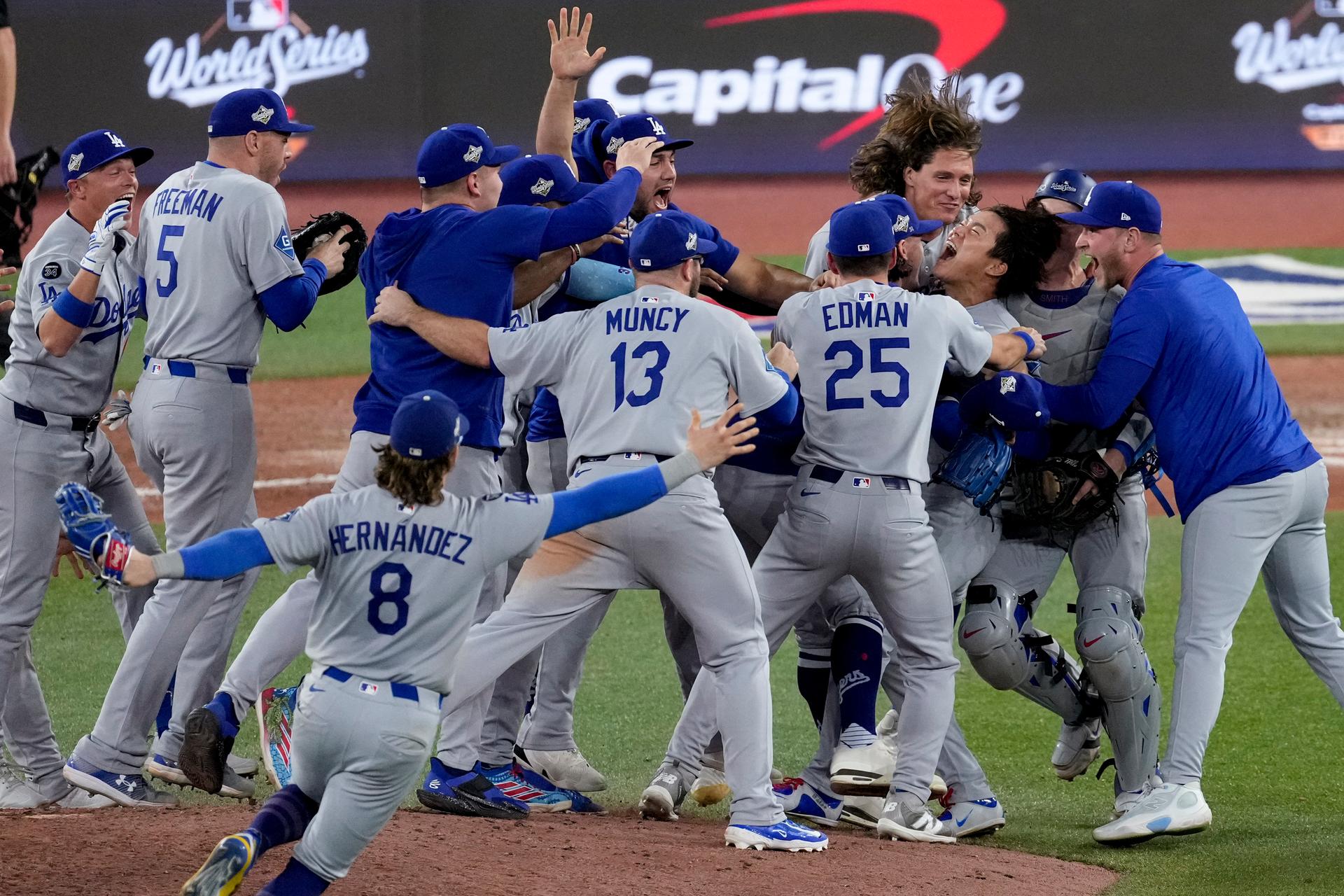 The Los Angeles Dodgers surround pitcher Yoshinobu Yamamoto as they celebrate their win in Game 7 of baseball's World Series in Toronto on Sunday. (AP Photo/Ashley Landis)