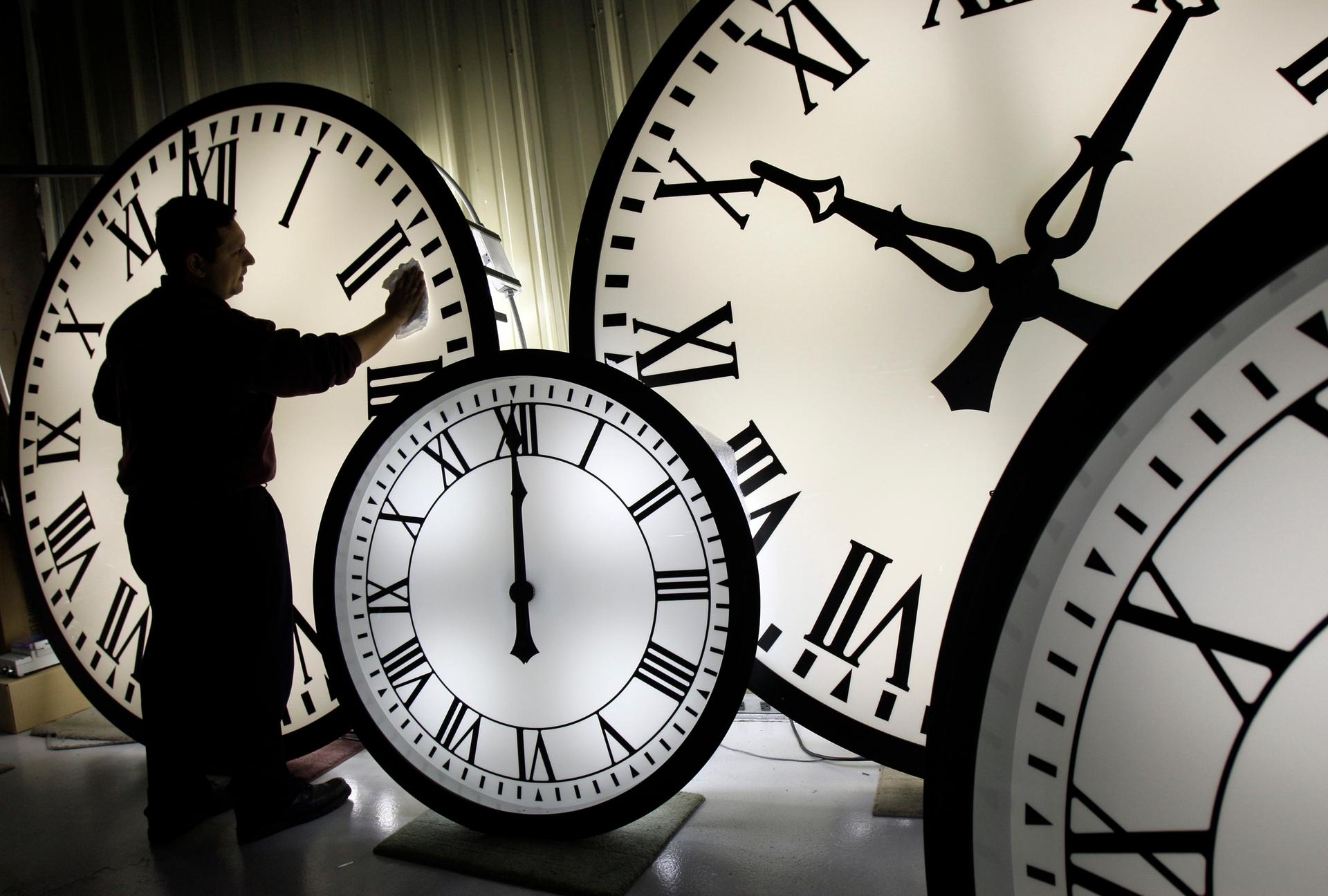 Electric Time Co. employee Walter Rodriguez cleans the face of an 84-inch Wegman clock at the plant in Medfield, Mass., 2008.