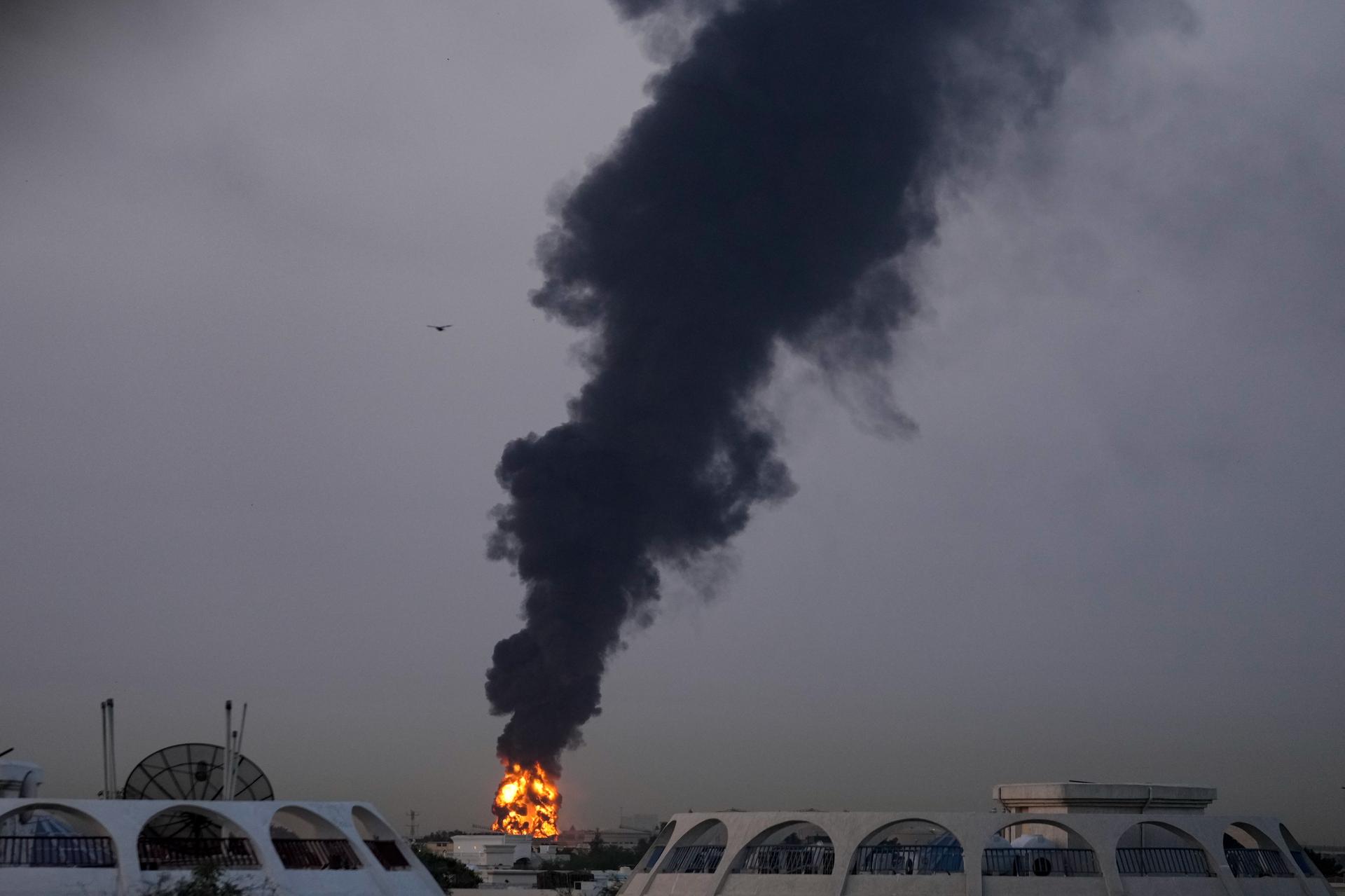 Fire and plumes of smoke rise after a drone struck a fuel tank, forcing the temporary suspension of flights at Dubai International Airport on Monday.