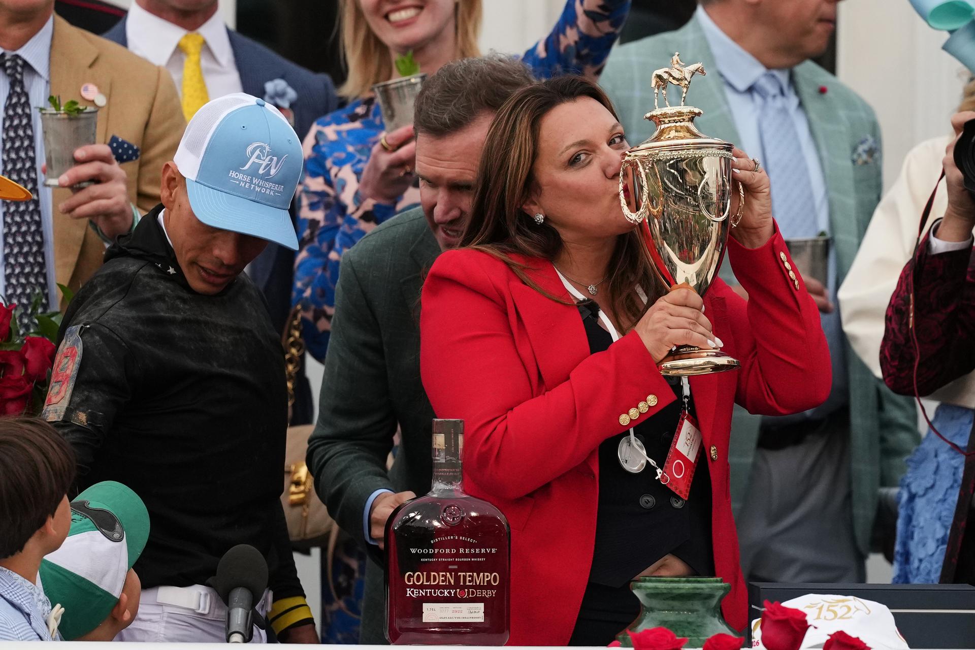 Trainer Cherie DeVaux kisses the trophy after a victory by Golden Tempo in the 152nd running of the Kentucky Derby horse race on Saturday. (AP Photo/Abbie Parr)