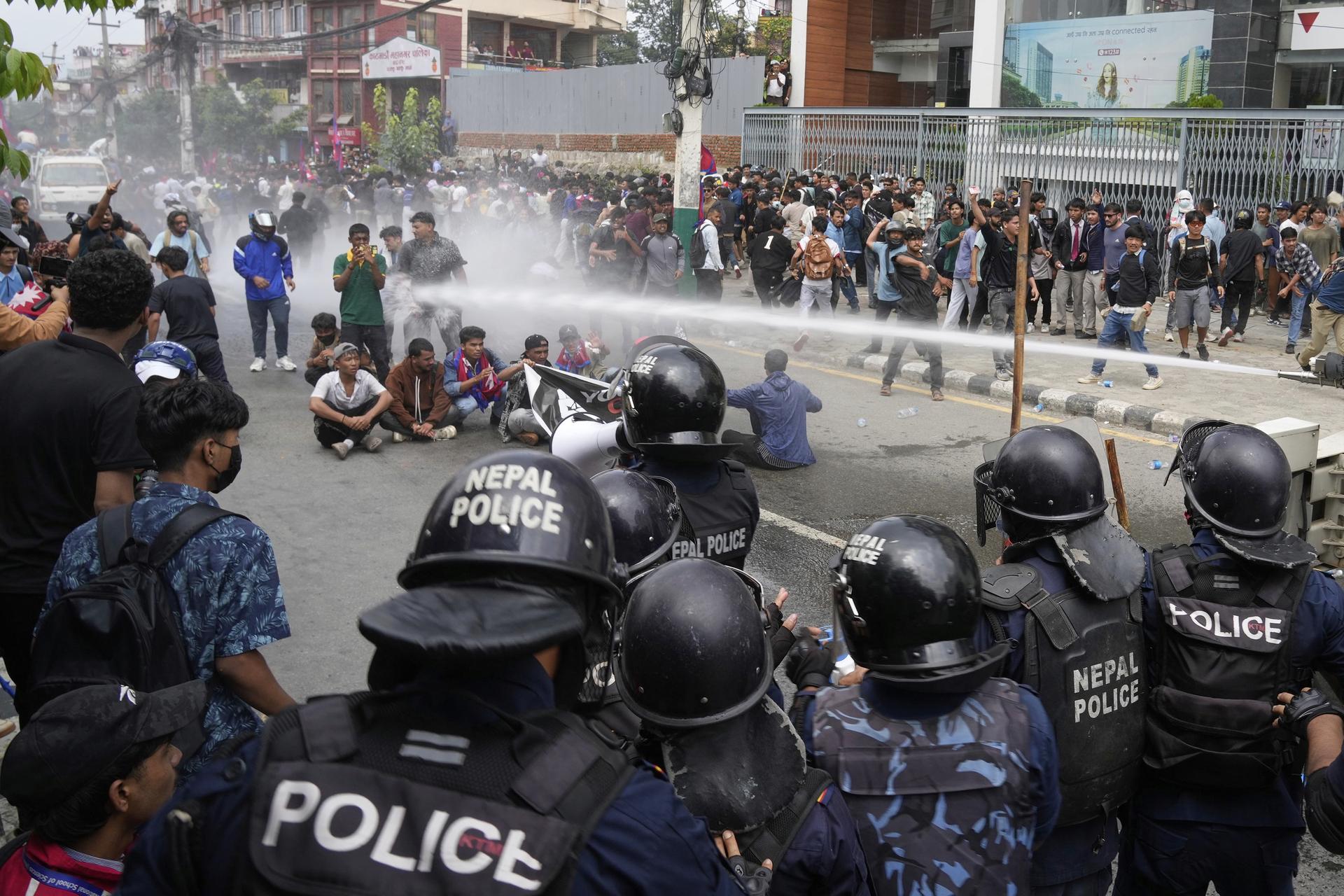 Riot police use water cannons on protesters during clashes outside parliament building in Kathmandu, Nepal, on Monday. (AP Photo/Niranjan Shrestha)