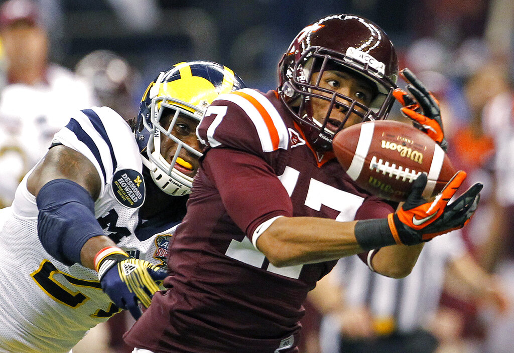 Virginia Tech cornerback Kyle Fuller (17) intercepts a pass intended for Michigan wide receiver Junior Hemingway (21) during the first quarter of the Sugar Bowl NCAA college football game in New Orleans, Tuesday, Jan. 3, 2012. (AP Photo/Dave Martin)