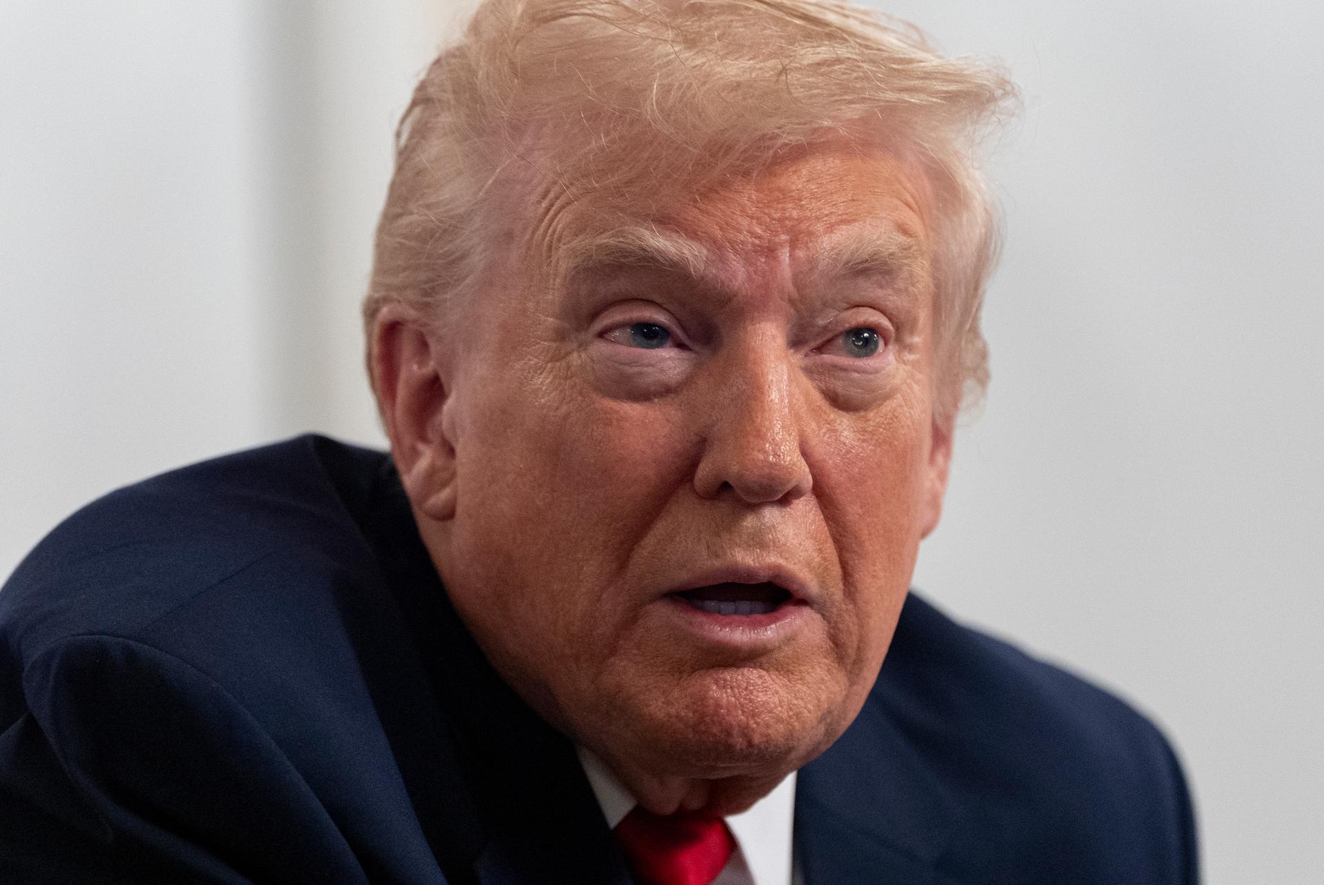 President Donald Trump speaks to reporters after speaking to troops via video from his Mar-a-Lago estate on Thanksgiving, in Palm Beach, Fla.