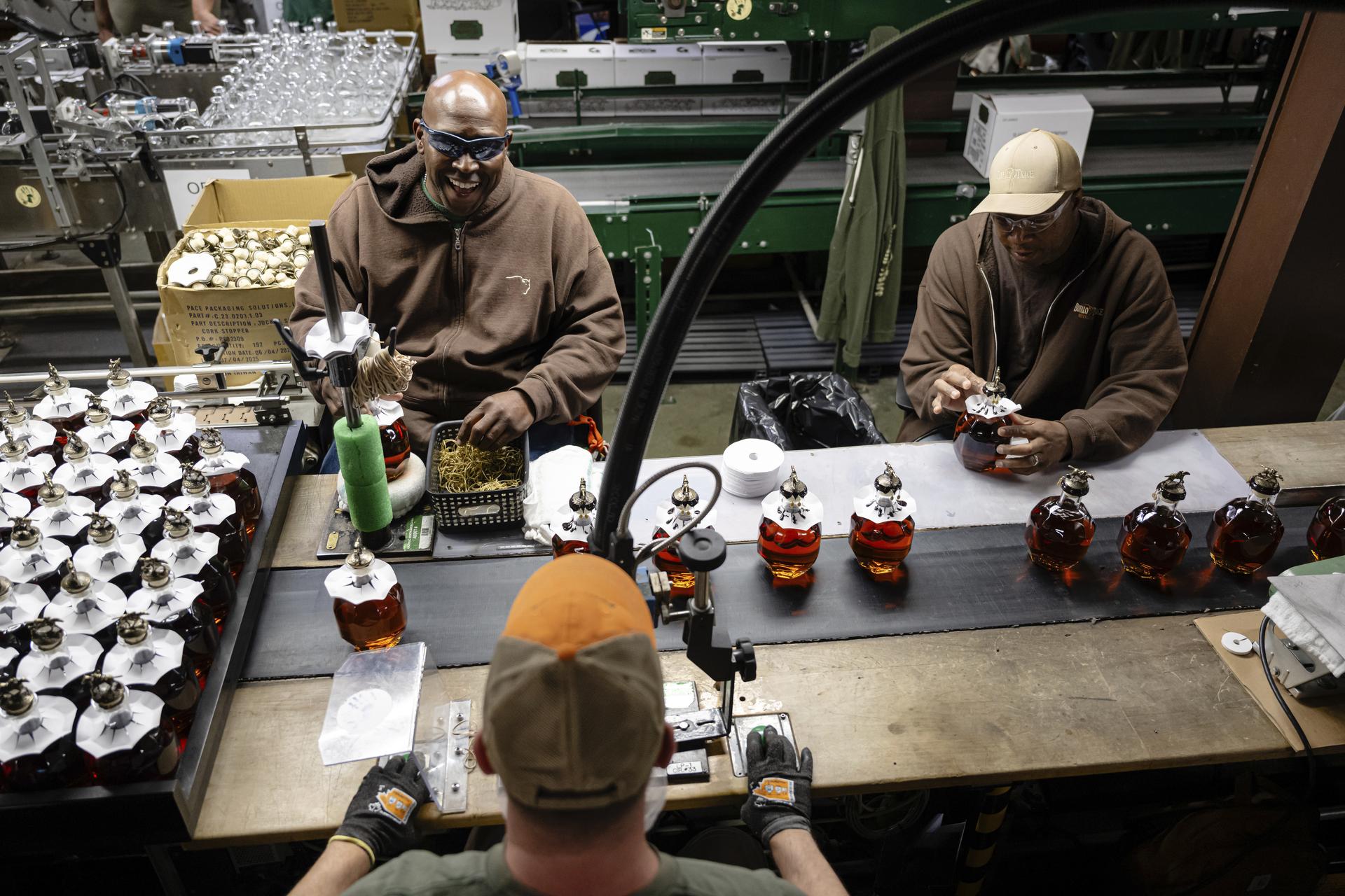Workers process freshly filled bottles of Blanton's bourbon in a bottling area at Buffalo Trace Distillery on Sept. 16 in Frankfort, Ky. (AP Photo/Jon Cherry)