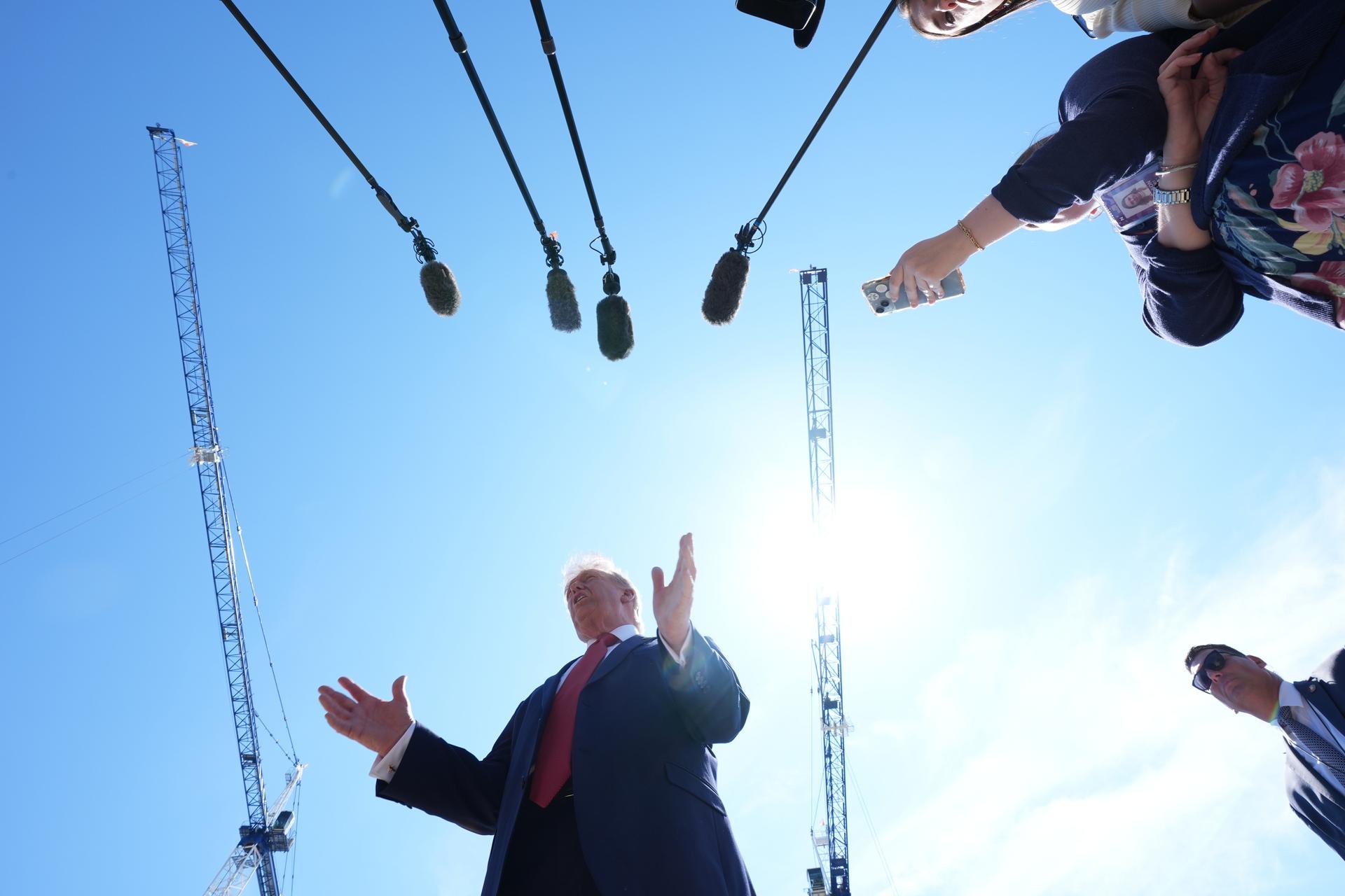 President Donald Trump speaks as he tours Ballroom construction around the outside the White House, Tuesday, in Washington.