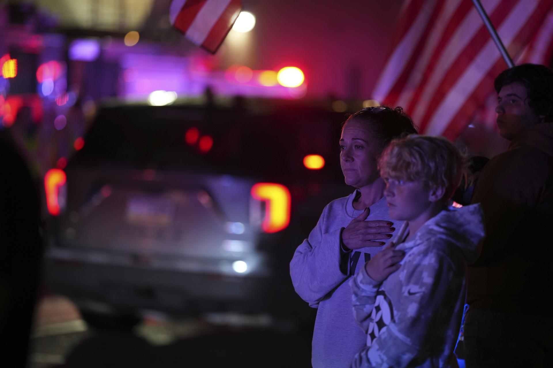 Attendees watch a procession Wednesday in Spring Grove, Pa., after multiple police officers were shot and killed. (AP Photo/Matt Slocum)