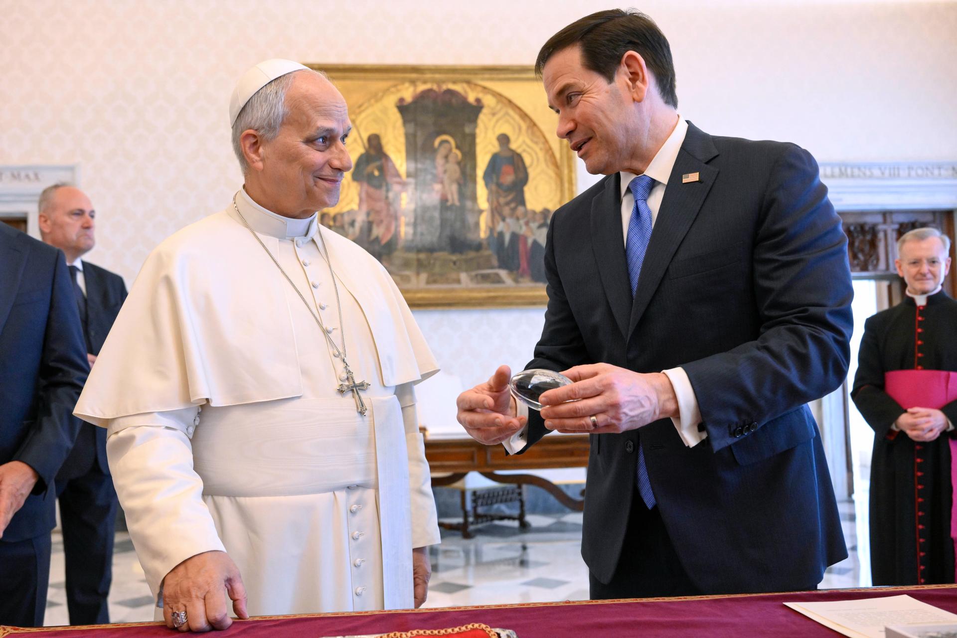 In this handout photo provided by Vatican Media Pope Leo XIV exchanges gifts with U.S. Secretary of State Marco Rubio as they meet in the pope's private library at the Vatican on Thursday. (Vatican Media via AP)