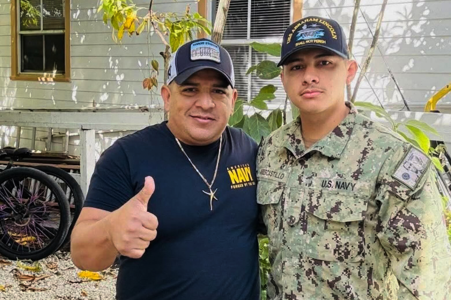 Katherine Delgado’s photo shows her step-father Luis Manuel Aviles, left, and her brother Joshua Aviles standing outside their home in October 2025, shortly before Joshua deployed on the USS Lincoln the following month in Key West, Fla.