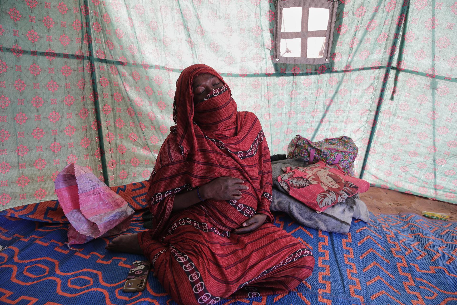 Nadra Mohamed Ahmed, 21, inside her tent at the newly established El-Afadh camp in Al Dabbah, Sudan's northern state, on Monday. (AP Photo/Marwan Ali)