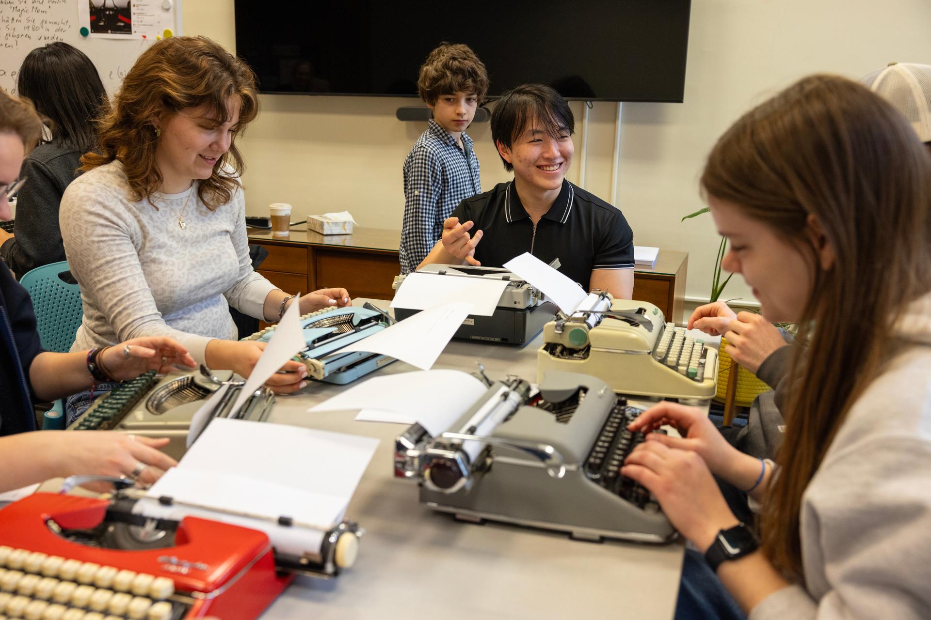 Ratchaphon Lertdamrongwong, a sophomore at Cornell University, laughs with classmates while using a typewriter on March 20, in Ithaca, N.Y.
