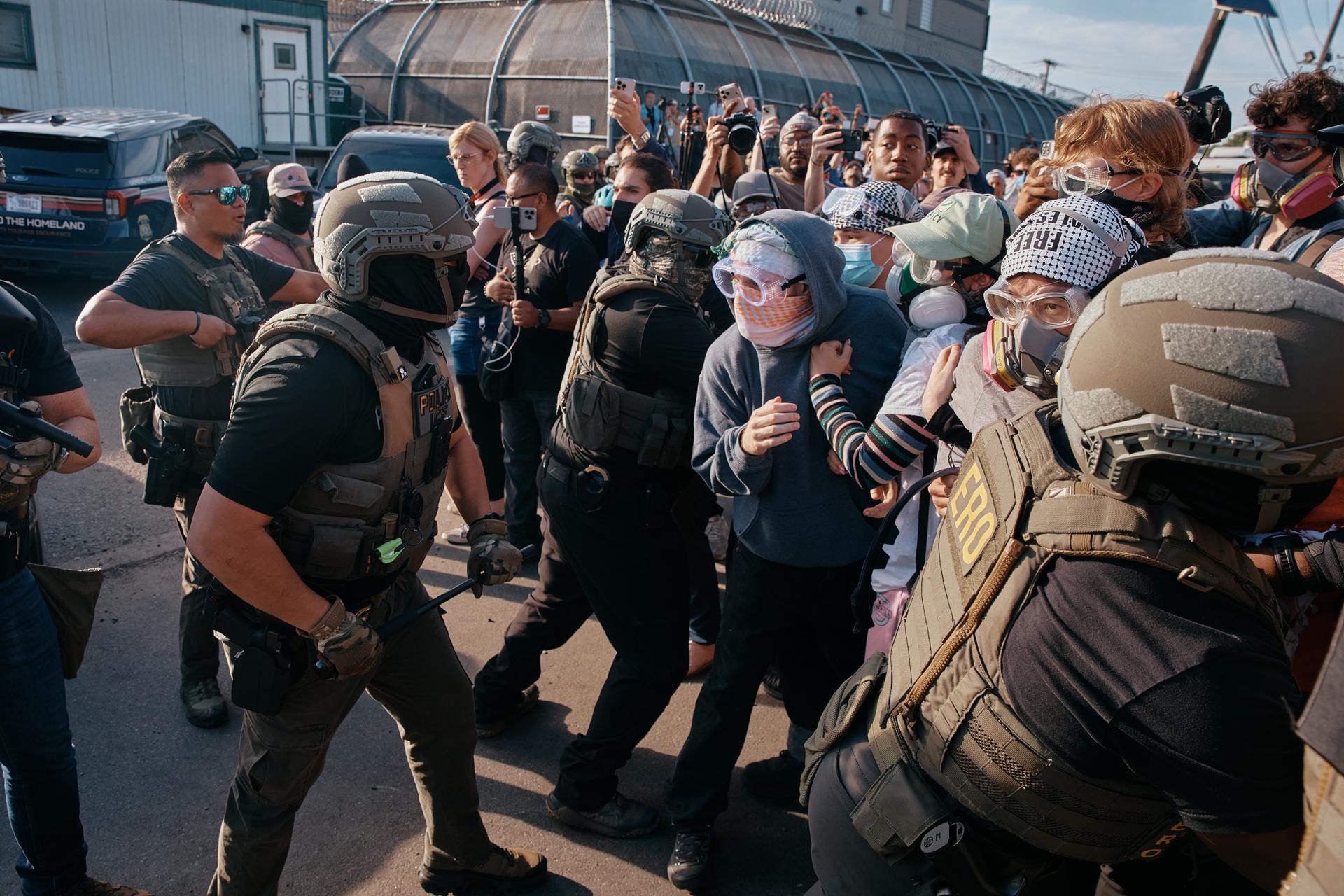 Protesters confront ICE agents outside the Delaney Hall detention center while demonstrating near the entrance gates, Wednesday, in Newark, N.J.