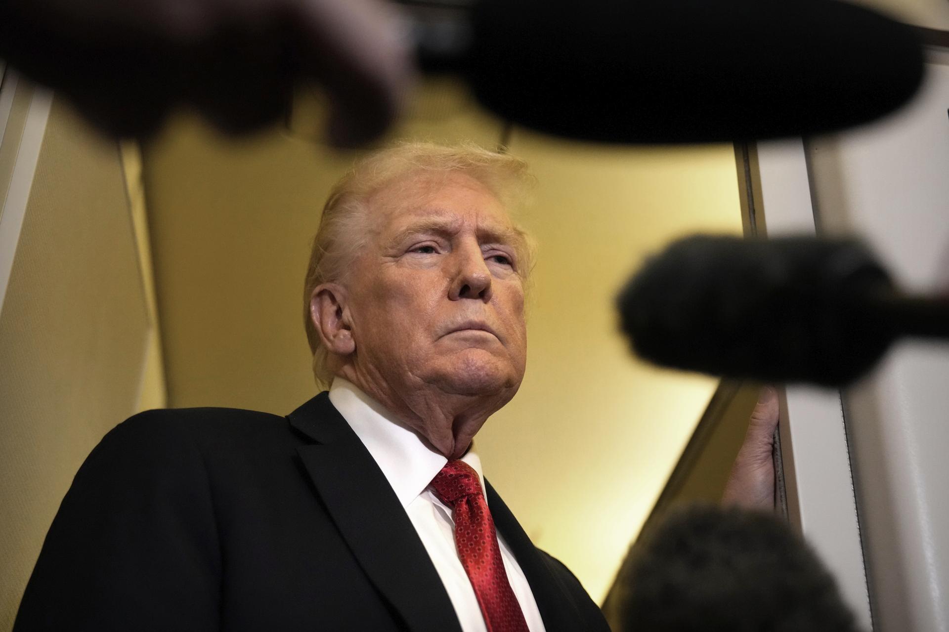 President Donald Trump speaks to reporters aboard Air Force One, Sunday, en route to Joint Base Andrews, Md.