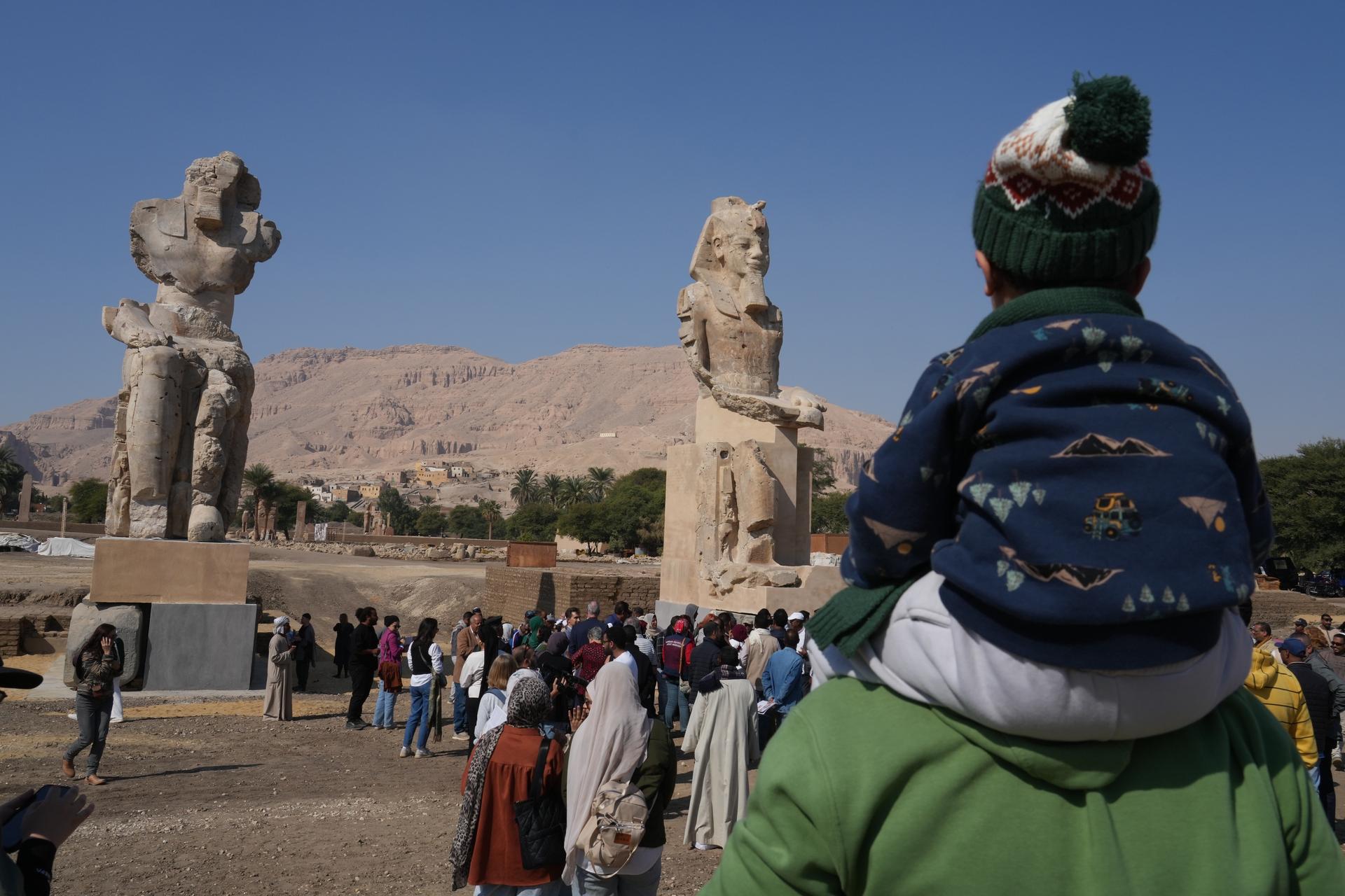 Visitors watch the two giant reassembled alabaster statues of Pharoah Amenhotep III, in the southern city of Luxor, Egypt, Sunday.