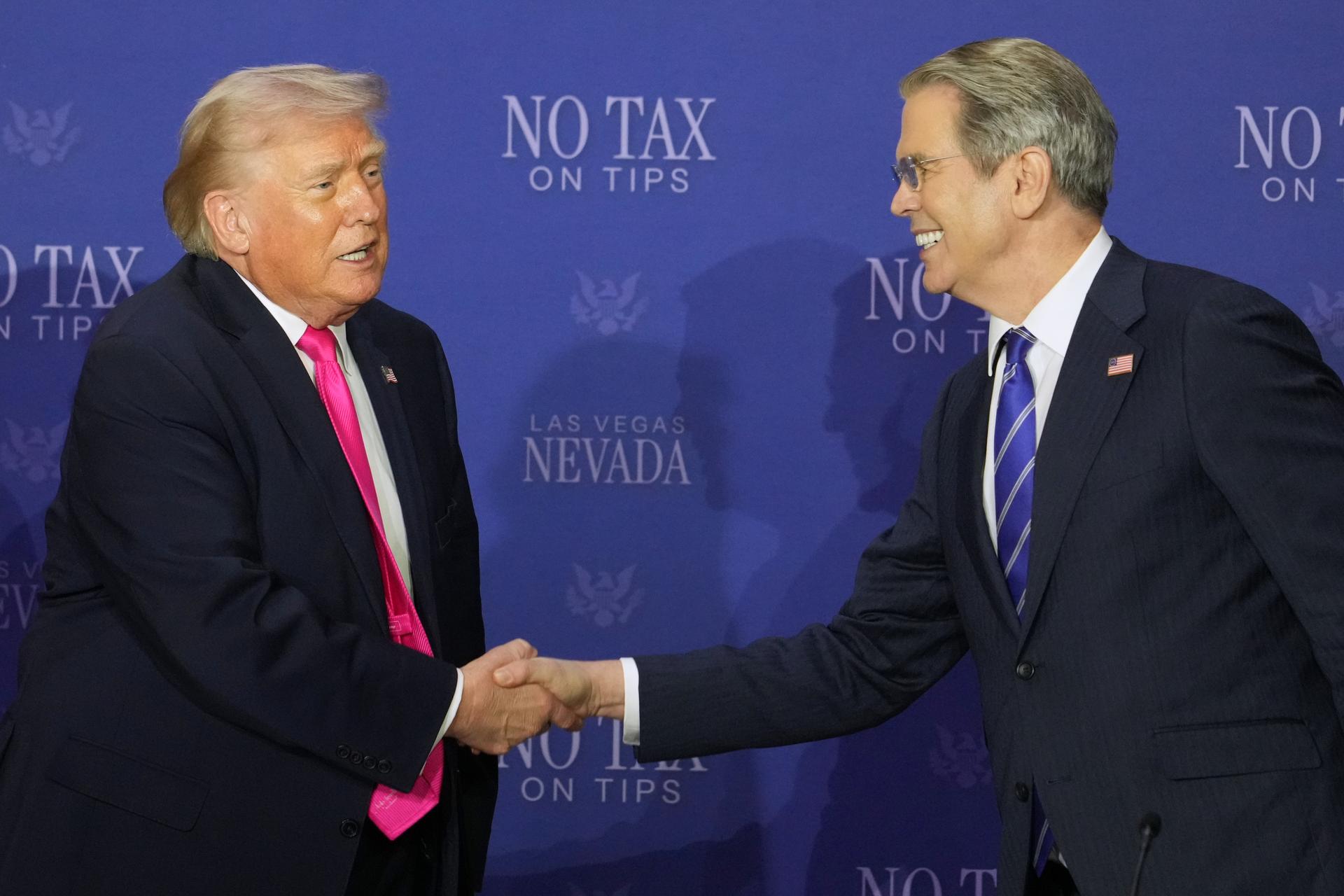 President Donald Trump shakes hands with Treasury Secretary Scott Bessent at a roundtable event about no tax on tips, April 16, in Las Vegas.