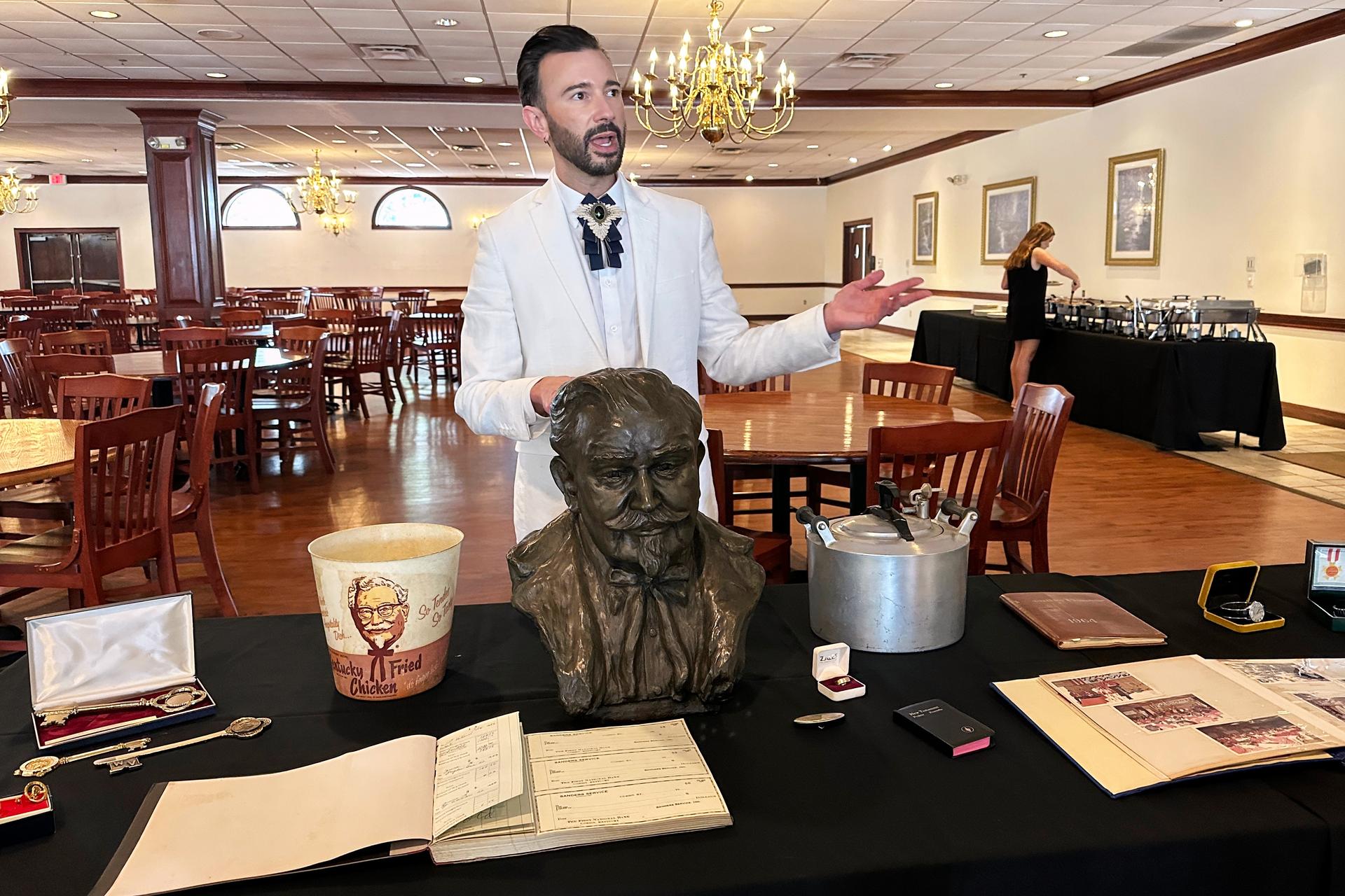 Auctioneer Jonathan Klunk with a display of personal items owned by KFC founder Harland Sanders, July 22, in Shelbyville, Ky.