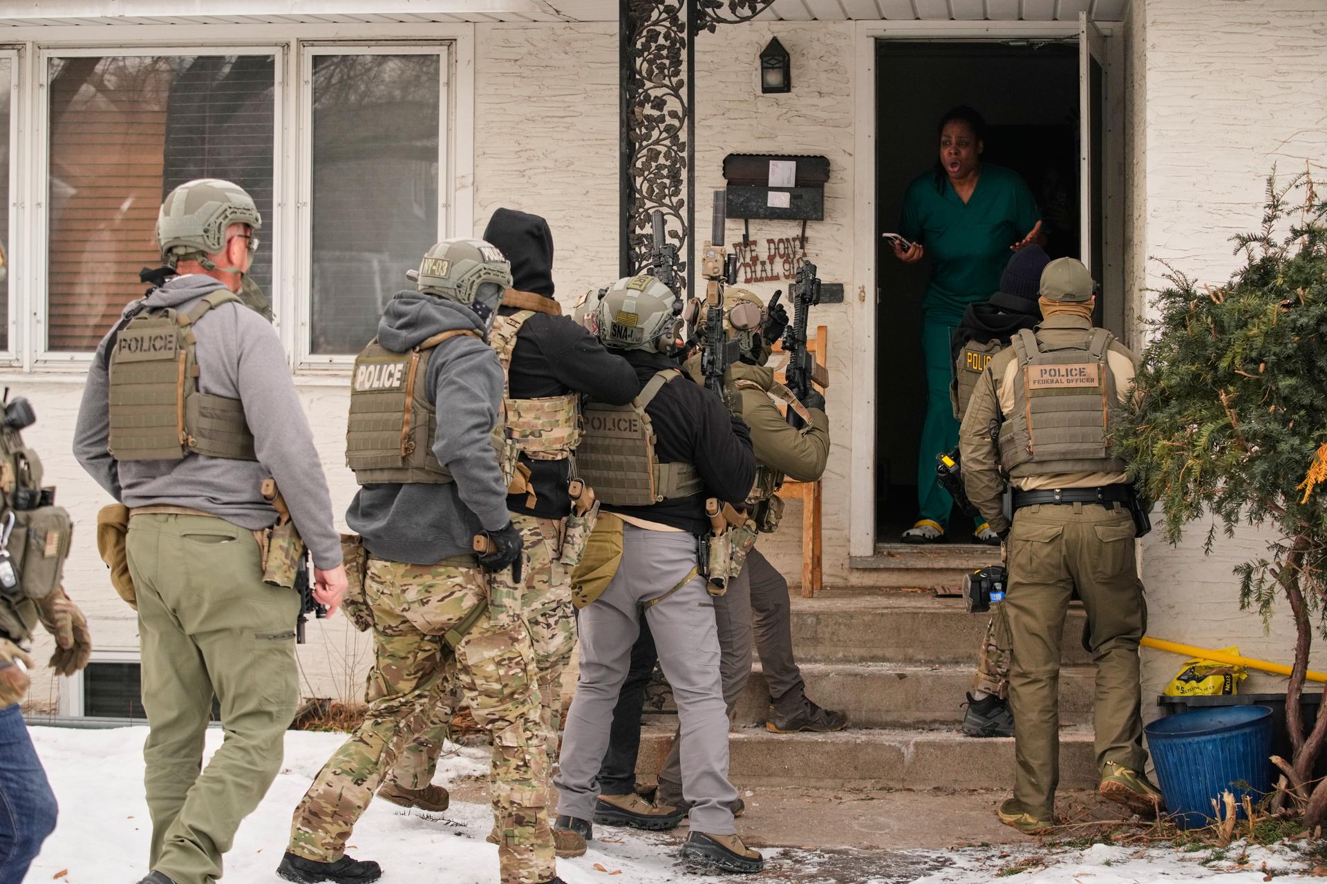 Teyana Gibson Brown, second from right, wife of Garrison Gibson, reacts after a federal immigration officer used a battering ram to break down a door before arresting Garrison Gibson, Jan. 11, 2026, in Minneapolis.