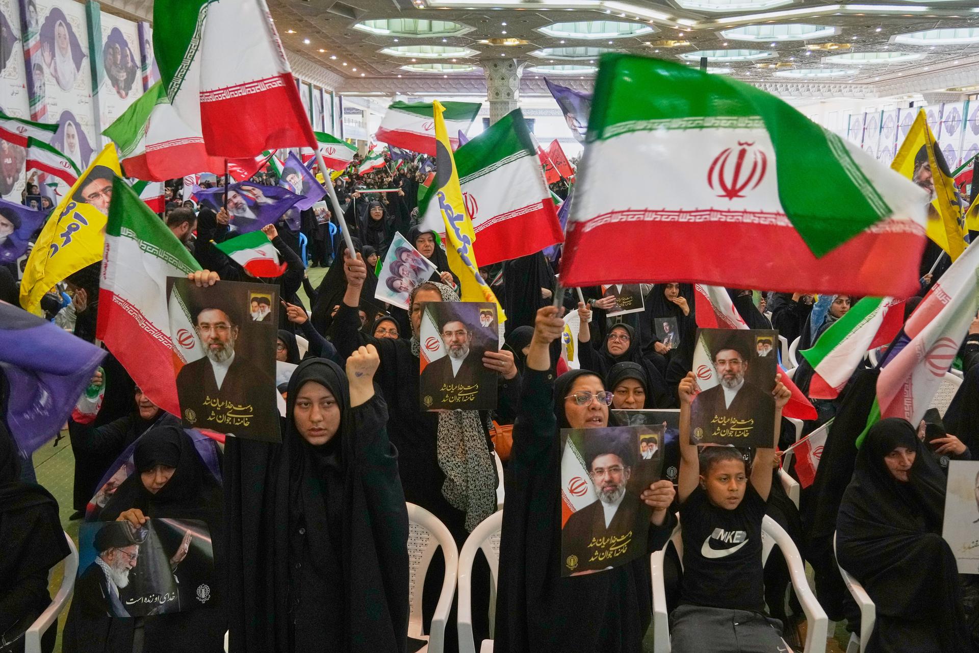 Government supporters hold Iranian flags and pictures of Iran’s Supreme Leader, Ayatollah Mojtaba Khamenei, during a ceremony at the Imam Khomeini Grand Mosque in Tehran, Iran, Sunday. 