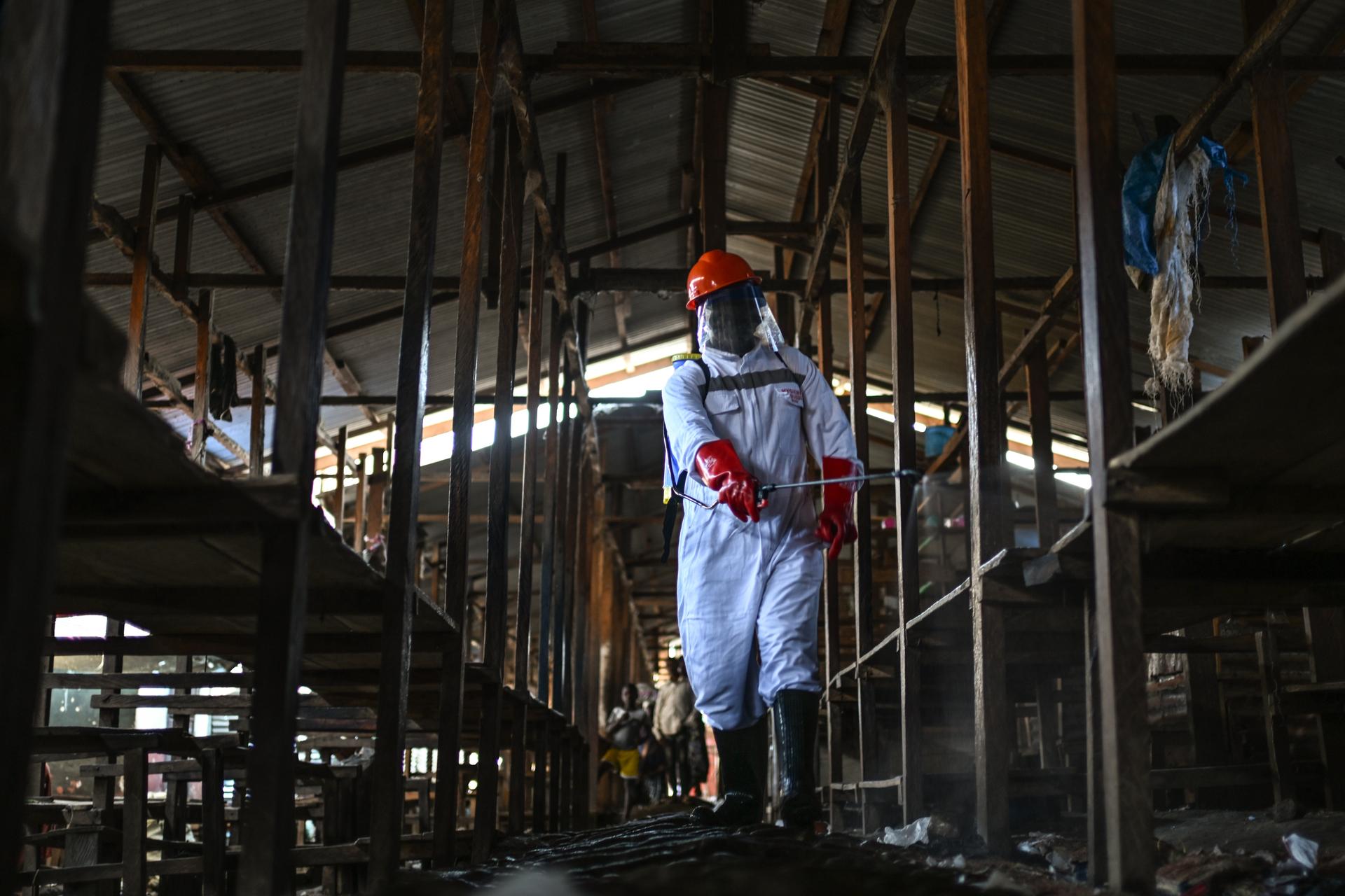 A sanitation worker from the Bunia city government sprays chlorine to disinfect the central market in Bunia, Congo, on Saturday. (AP Photo/Moses Sawasawa)