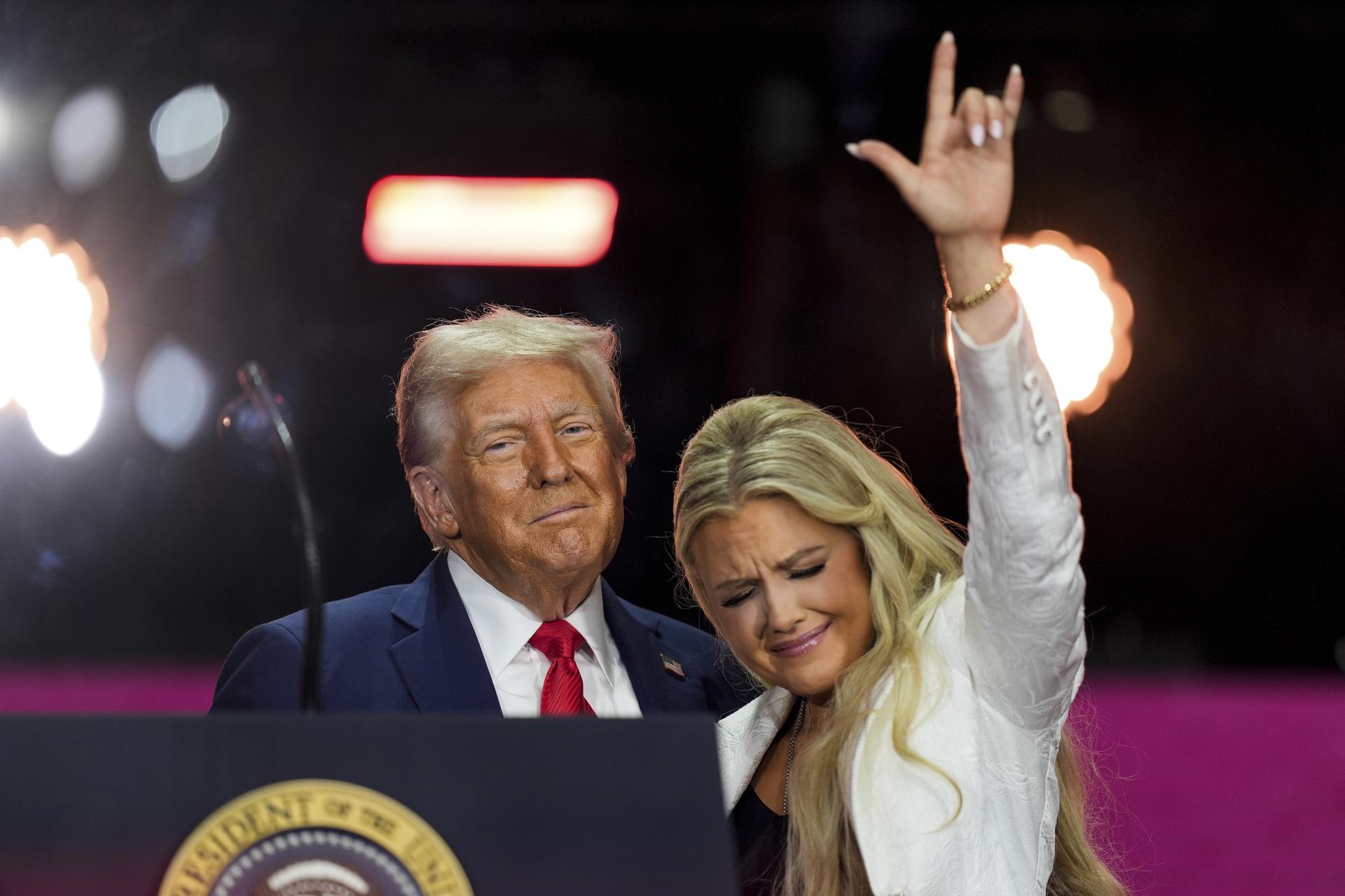 President Donald Trump, left, stands with Erika Kirk at the conclusion of a memorial for her husband, conservative activist Charlie Kirk, Sunday, at State Farm Stadium in Glendale, Ariz. 