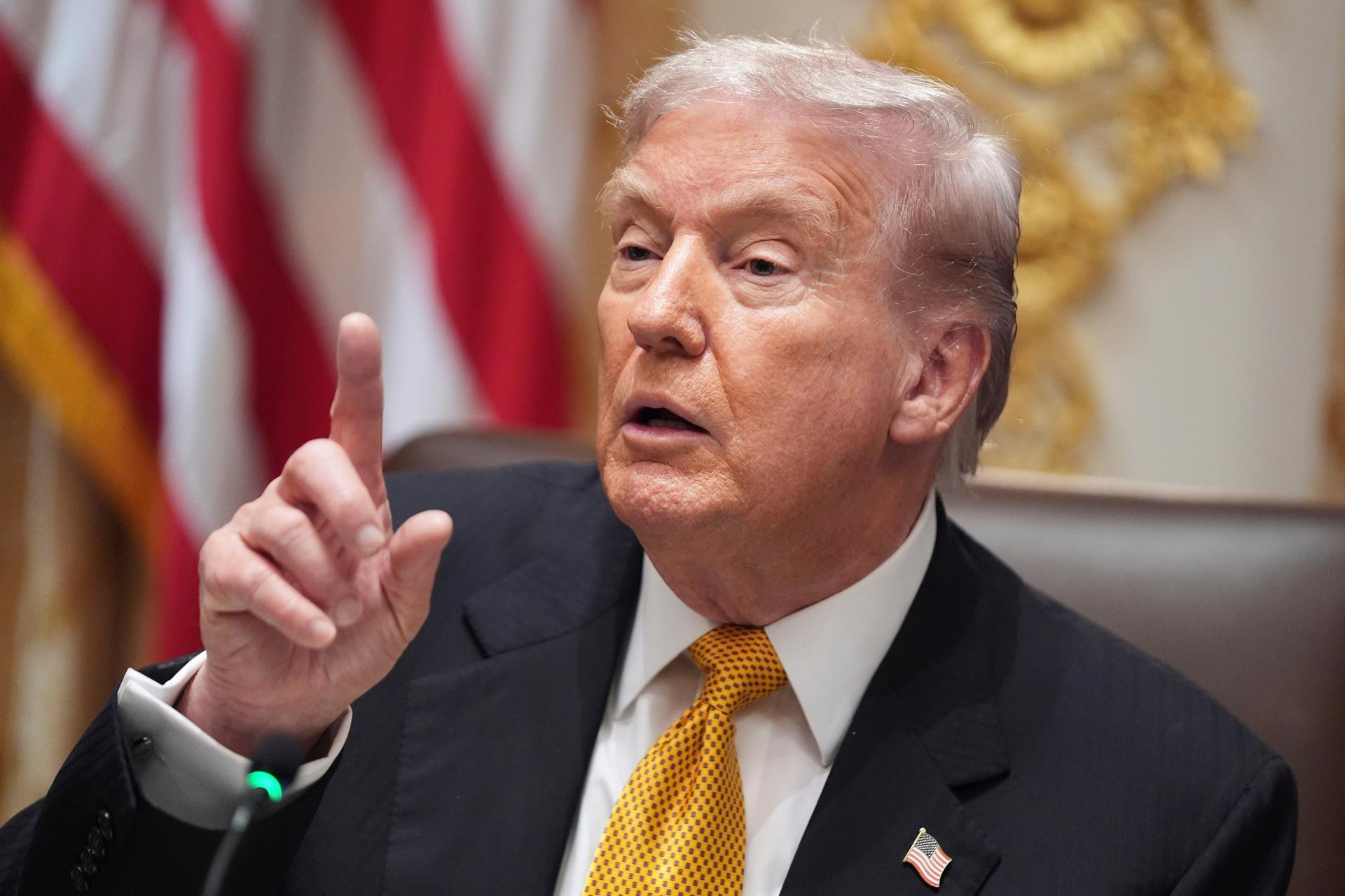 President Donald Trump speaks with reporters in the Cabinet Room of the White House, Friday, in Washington.