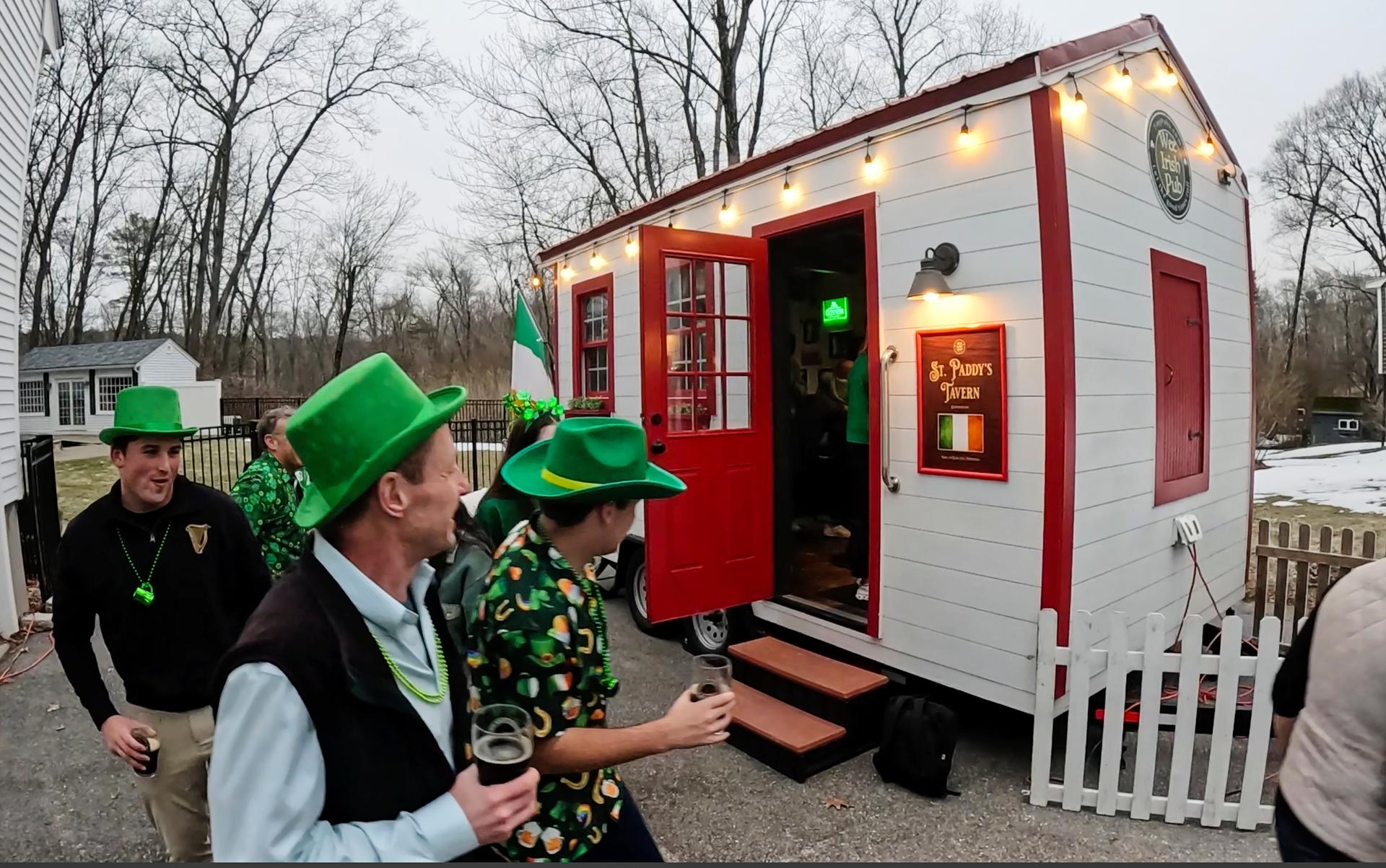 Revelers gather for an early St. Patrick's Day party in a rented tiny pub, Friday, in Andover, Mass.