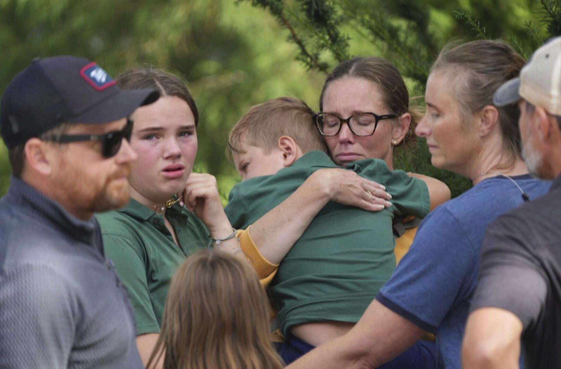 Parents comfort their children after a shooting at Annunciation Church on Wednesday in Minneapolis. 
