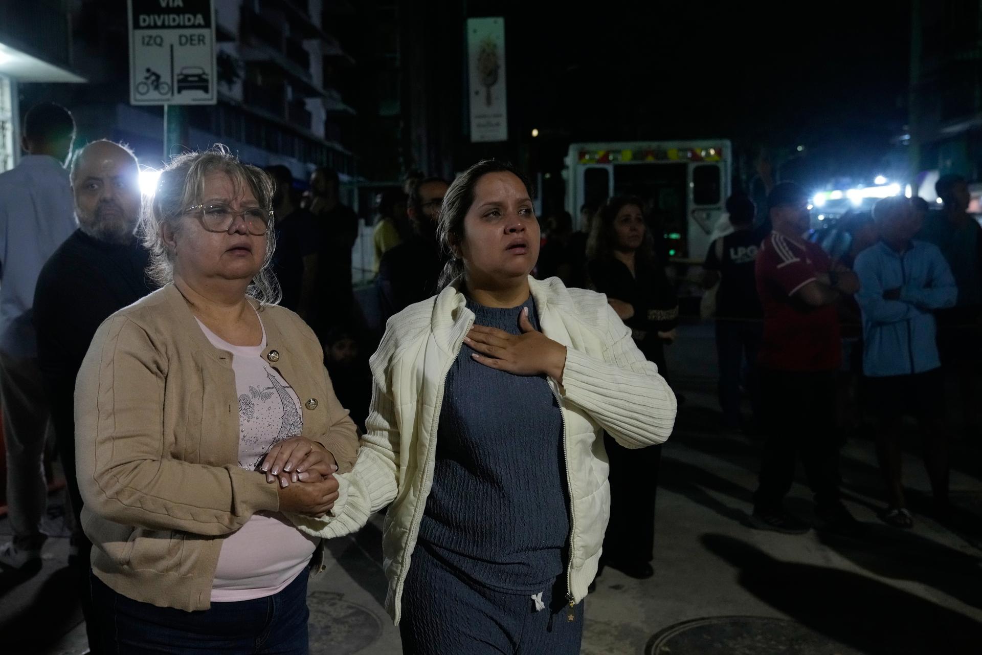 People remain outside their homes following an earthquake in Caracas, Venezuela, Thursday. 