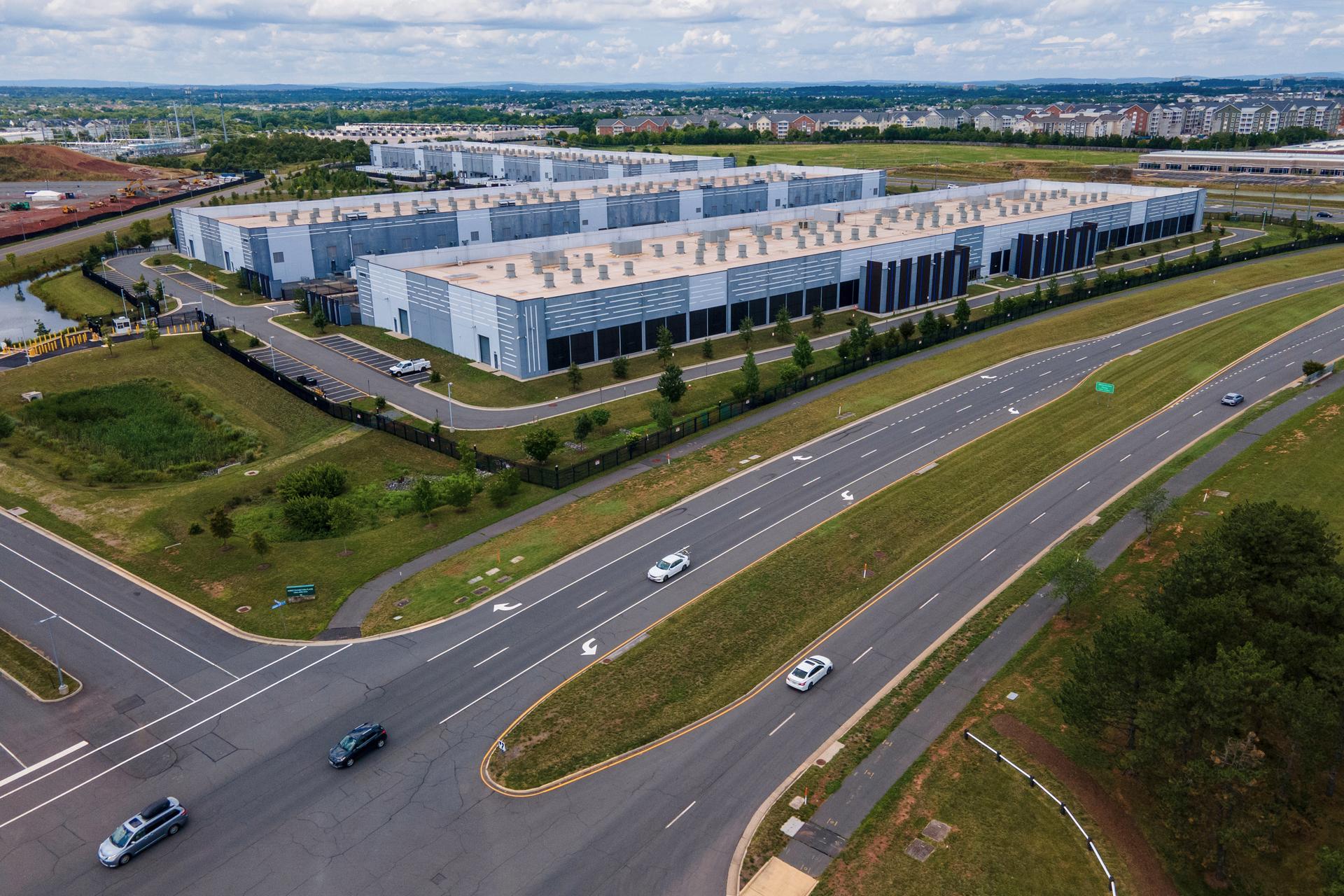 Cars drive past data centers in Ashburn, Va. in 2023. 