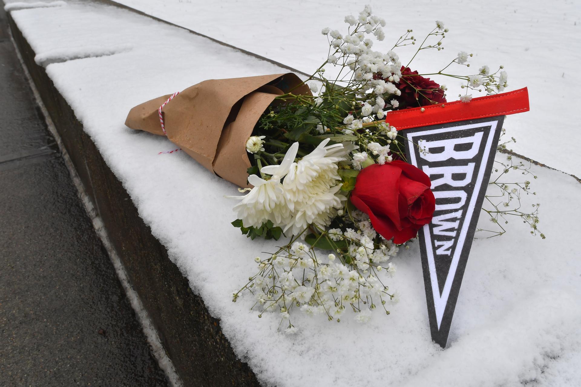 A bouquet of flowers rests on snow on the campus of Brown University on Sunday. (AP Photo/Steven Senne)