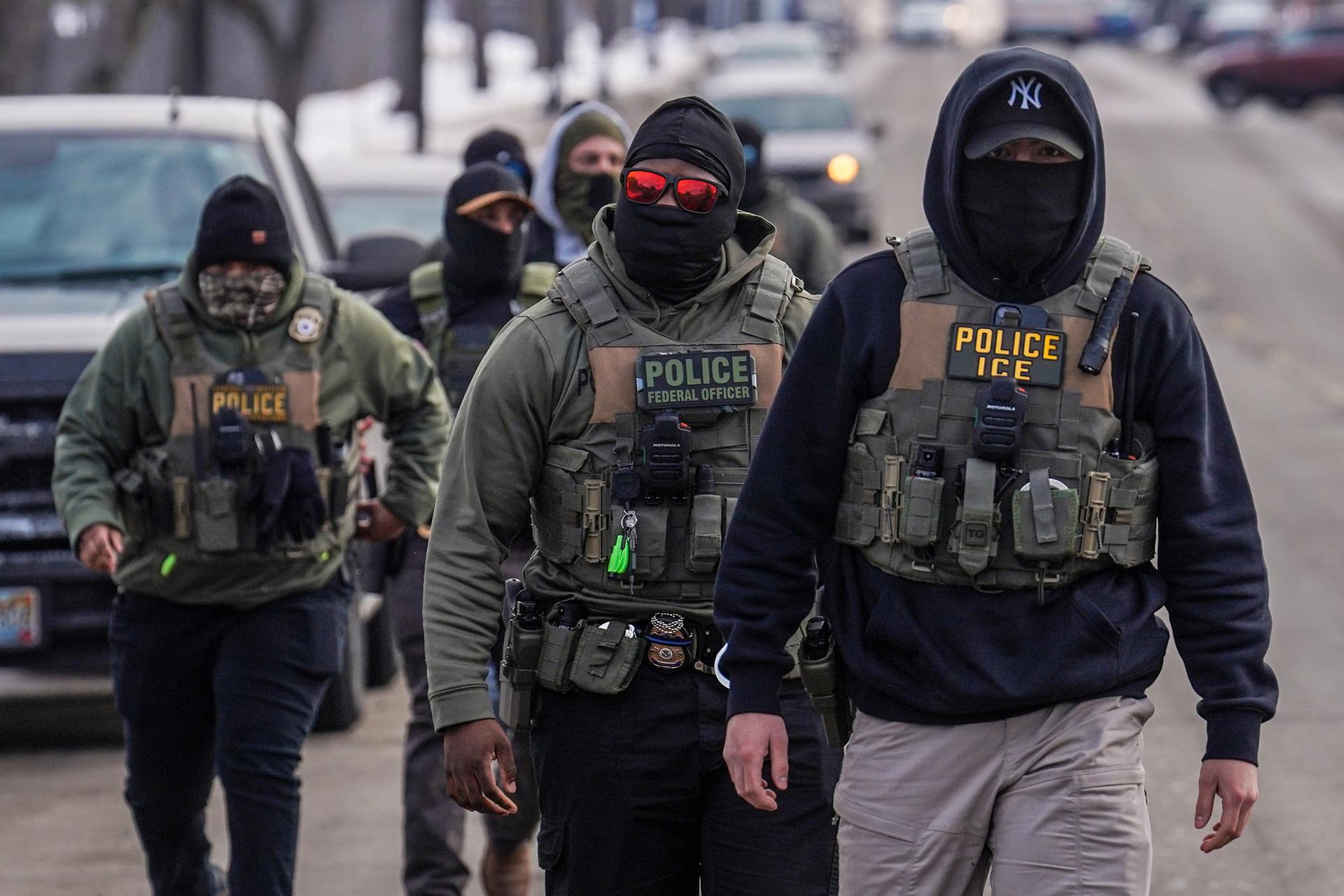 Federal agents walk down a street while conducting immigration enforcement operations in Minneapolis, February 5.