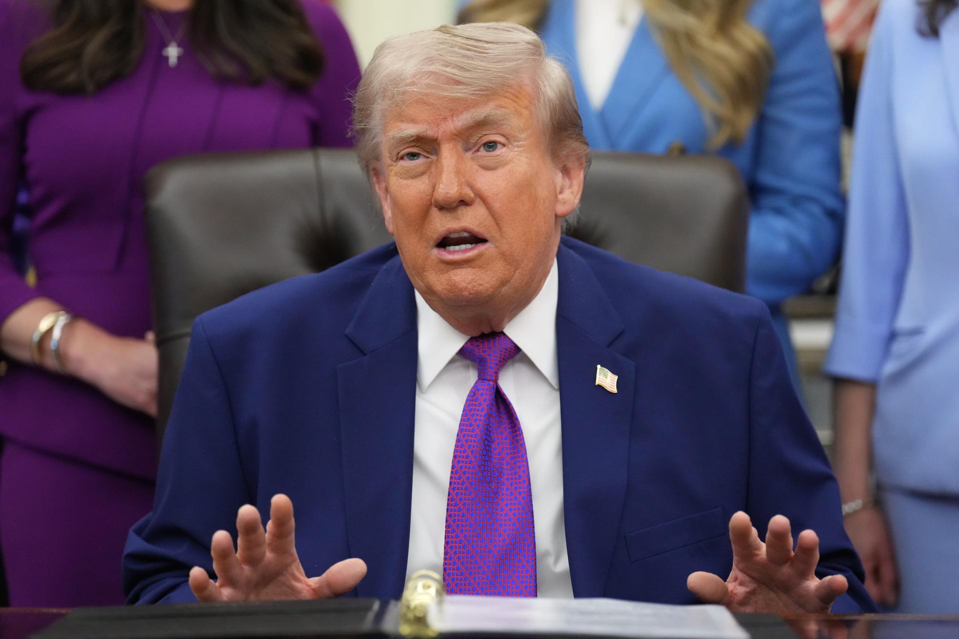 President Donald Trump speaks to reporters on Monday in the Oval Office of the White House, in Washington.